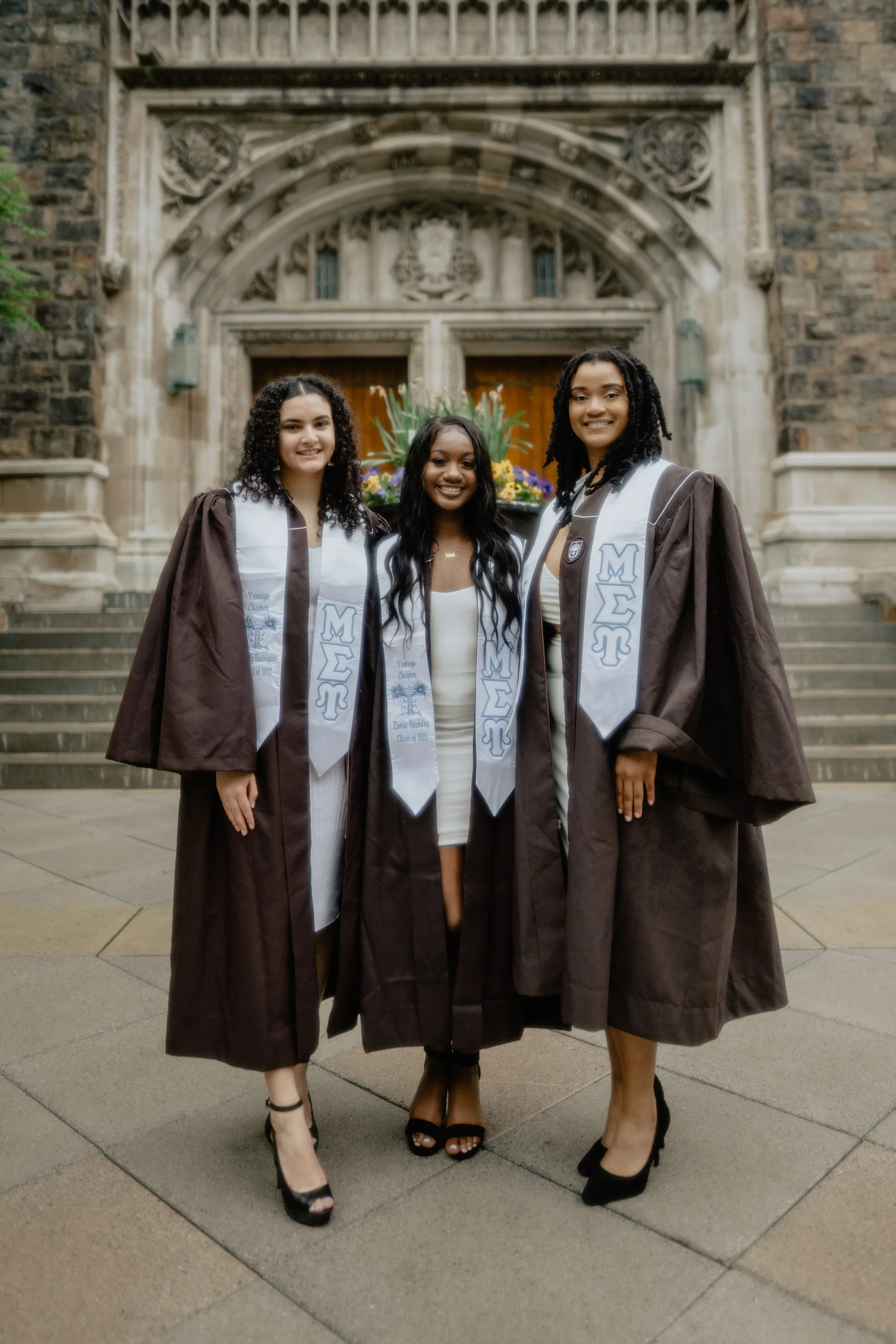 Three students pose for graduation photos