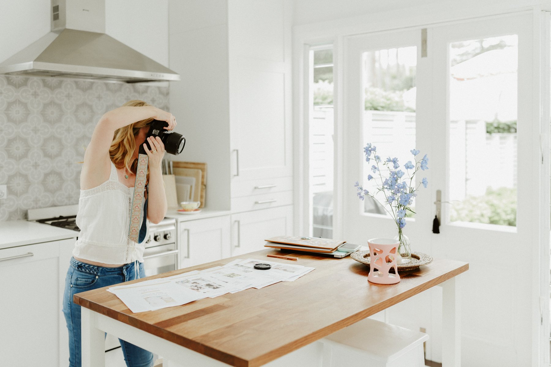 blonde female photographer taking photos in a kitchen