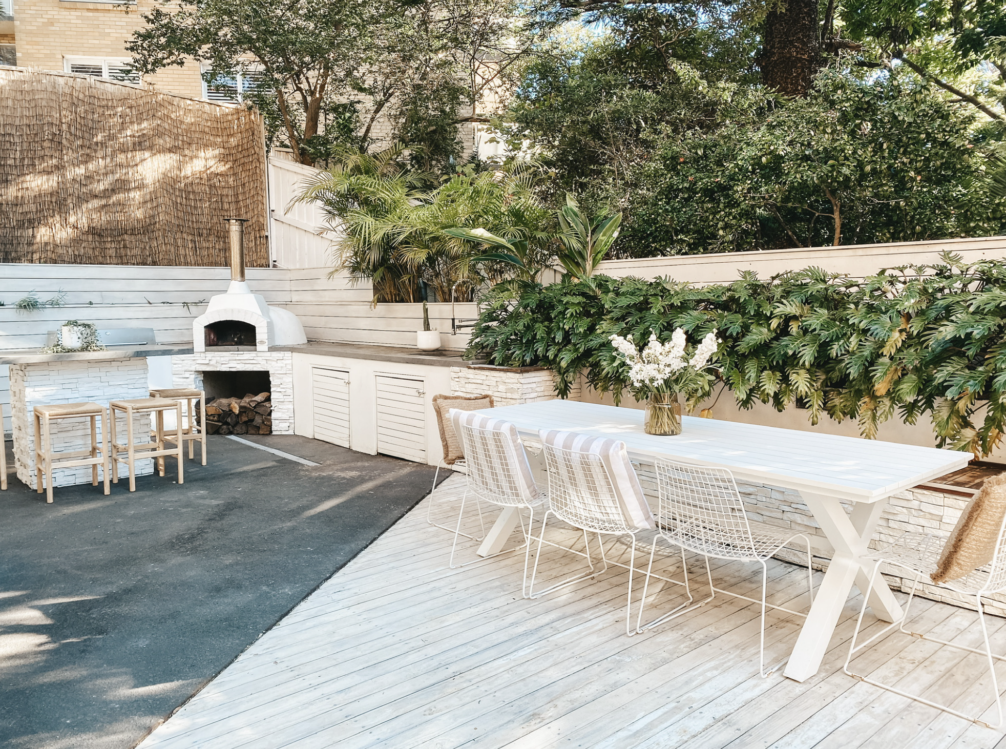 outdoor patio area with pizza oven and white dining table