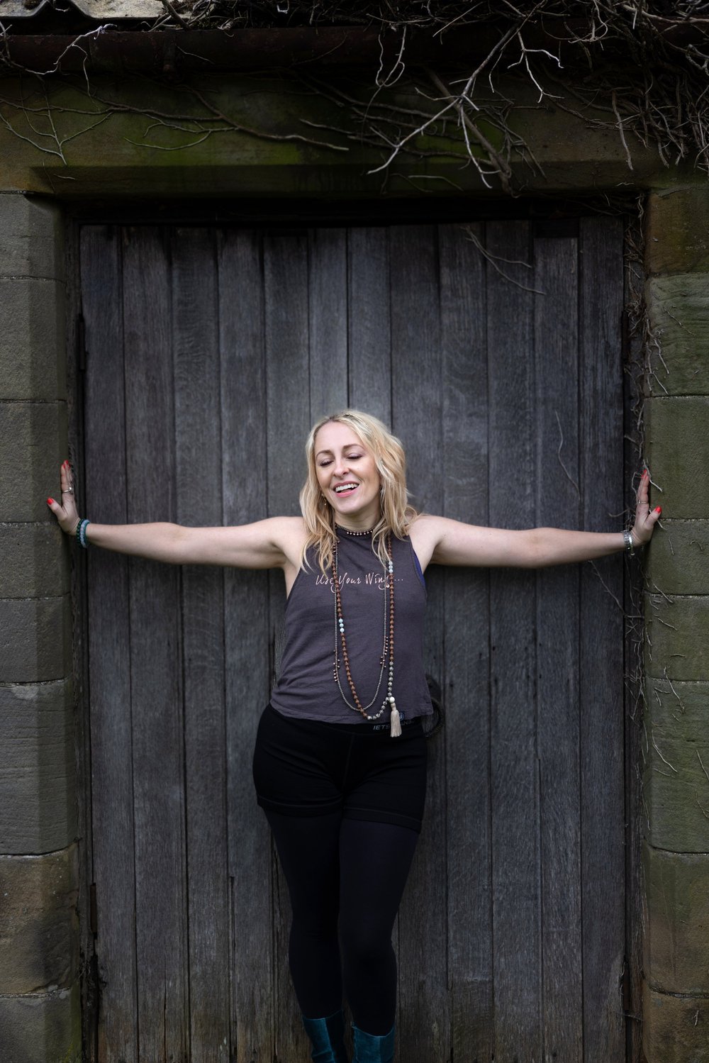 Lucy standing in a stone doorway, arms outstretched