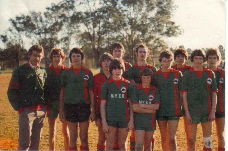 1980's 
 
Coach: Gary Neil
 
Players: Anthony Freeman [missing name], Patrick Randell (GK), Chris Norton (behind GK), [missing name], [missing name front of Goalkeeper] Sean Lomanaco, Steven Tibbins, Peter Blair, Scott Coggan