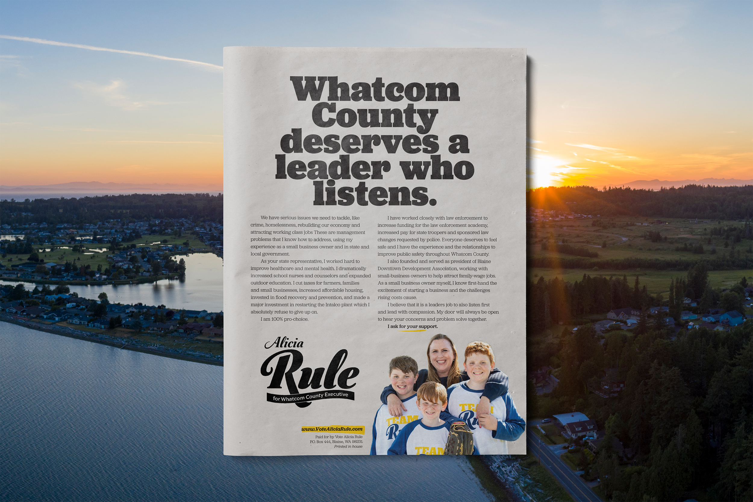 A campaign ad for Alicia Rule, a candidate for Whatcom County Executive, overlaid on a scenic aerial view of a landscape with water and a sunset. The ad includes her priorities such as listening to residents and addressing crime, healthcare, and educ