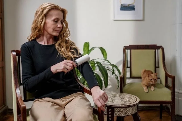 woman in black top using a lint roller