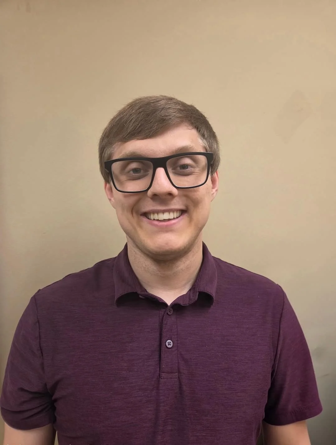 man in maroon shirt with glasses
