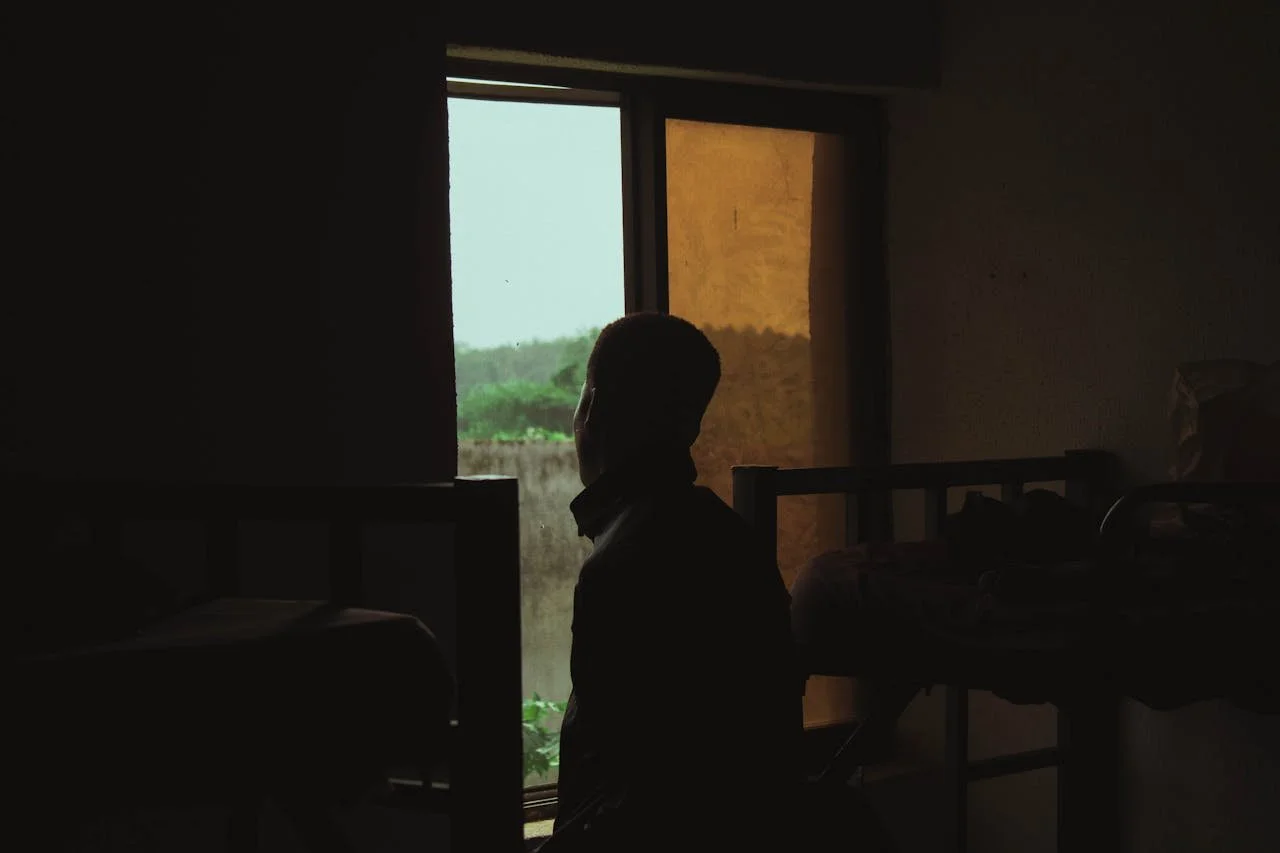 silhouette-of-a-man-standing-by-the-window-in-a-room