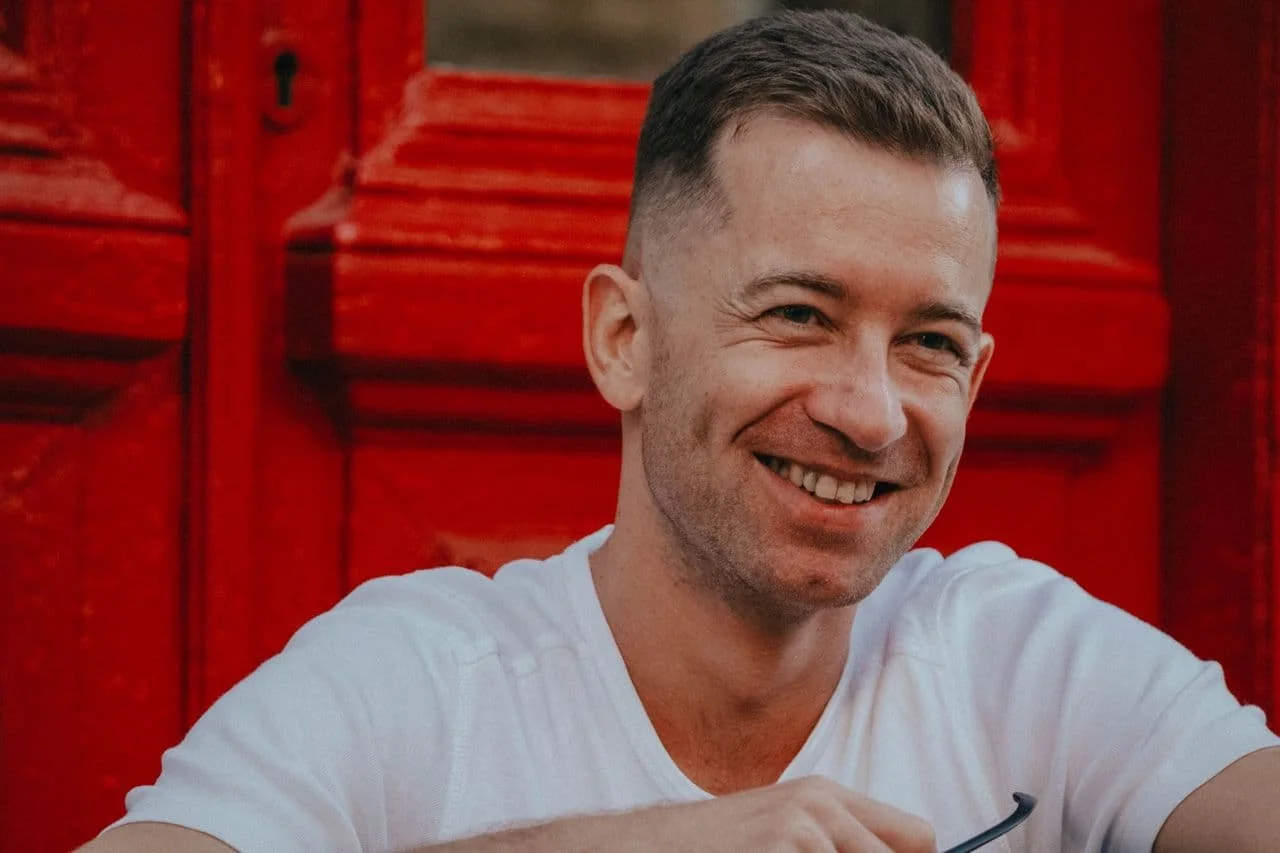 smiling-man-in-front-of-red-door