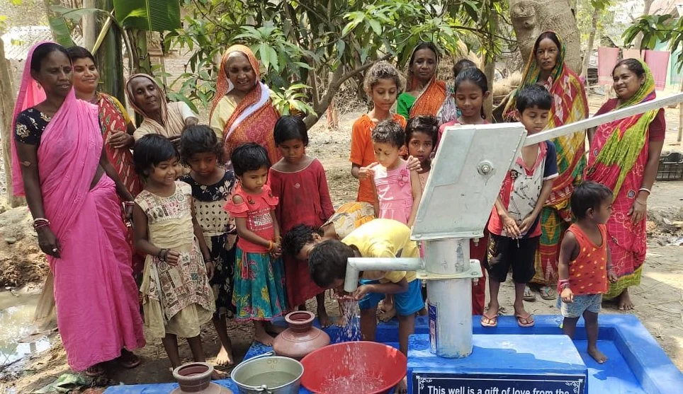 Young children getting clean water from a hand pump
