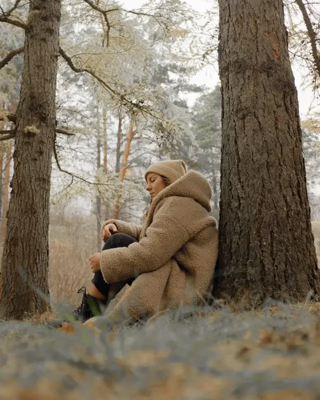 a person looking sad next to a tree