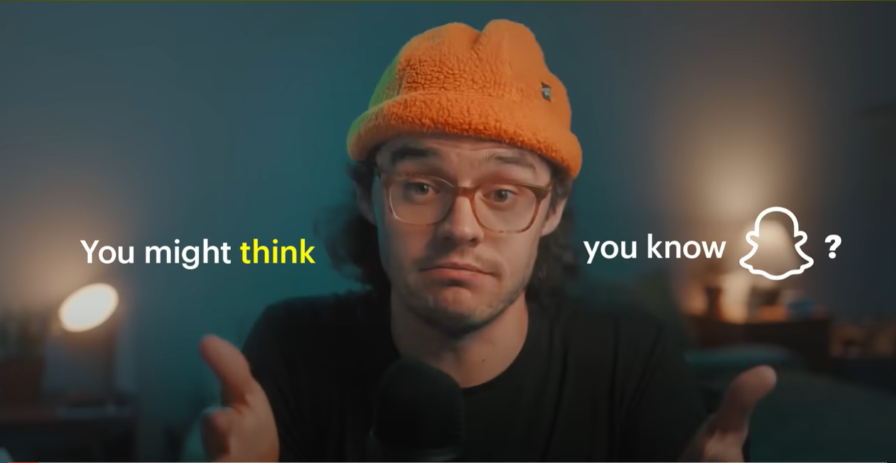 A young man with glasses, wearing an orange beanie, sitting in front of a microphone in a dimly lit room with two lamps and a bed in the background. Text on the image says, "You might think you know" with a Snapchat ghost icon and a question mark.