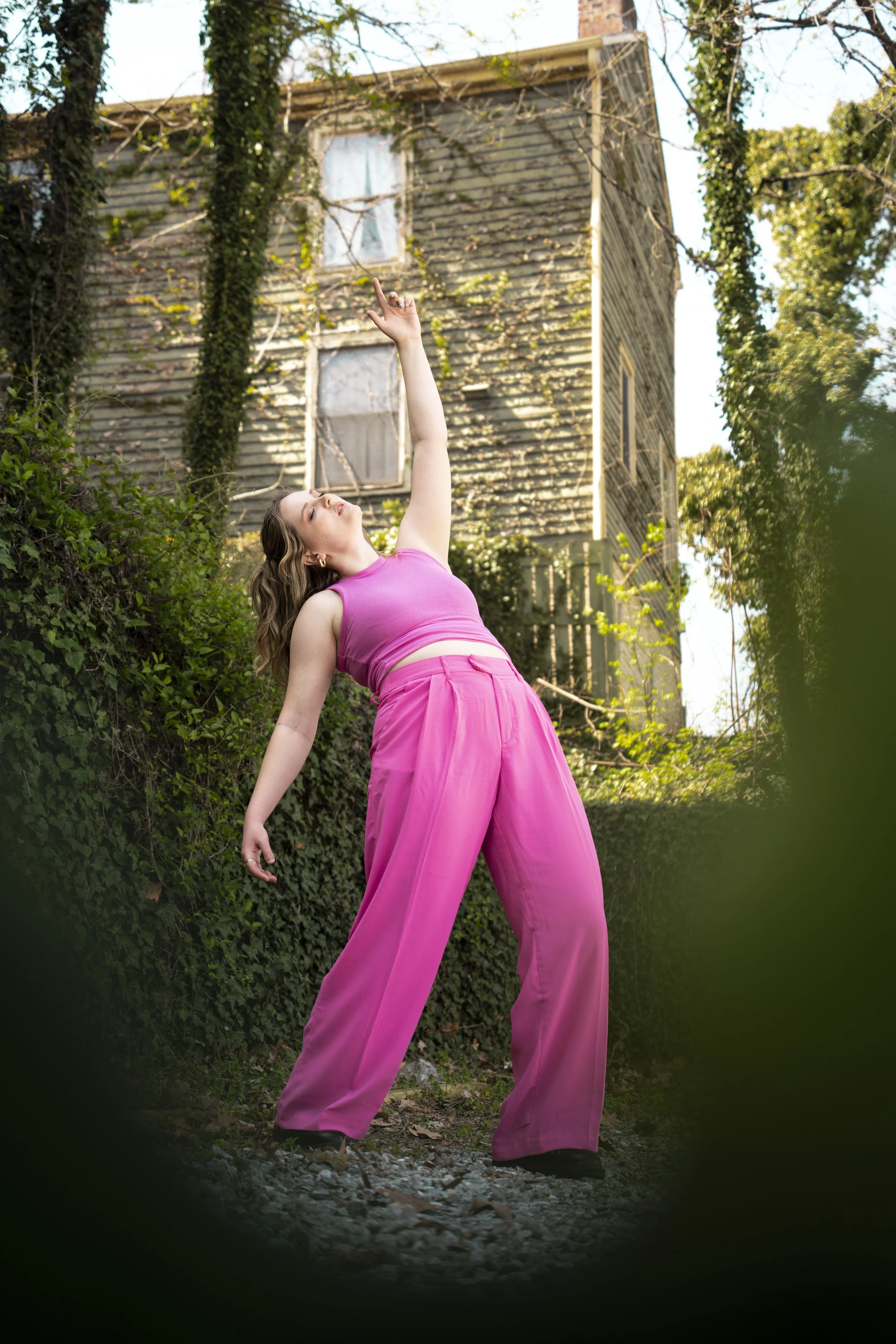 Girl in bright pink outfit standing in woodland ivy.JPG