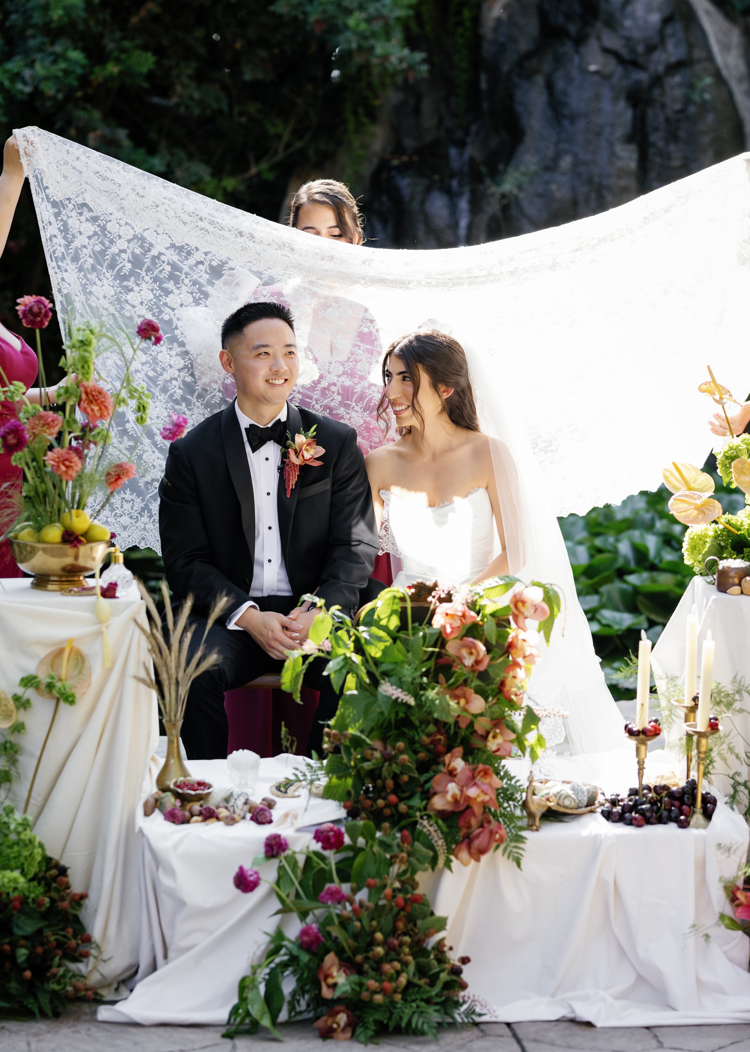 Multicultural wedding sitting at their Sofreh during the Kaleh Ghand