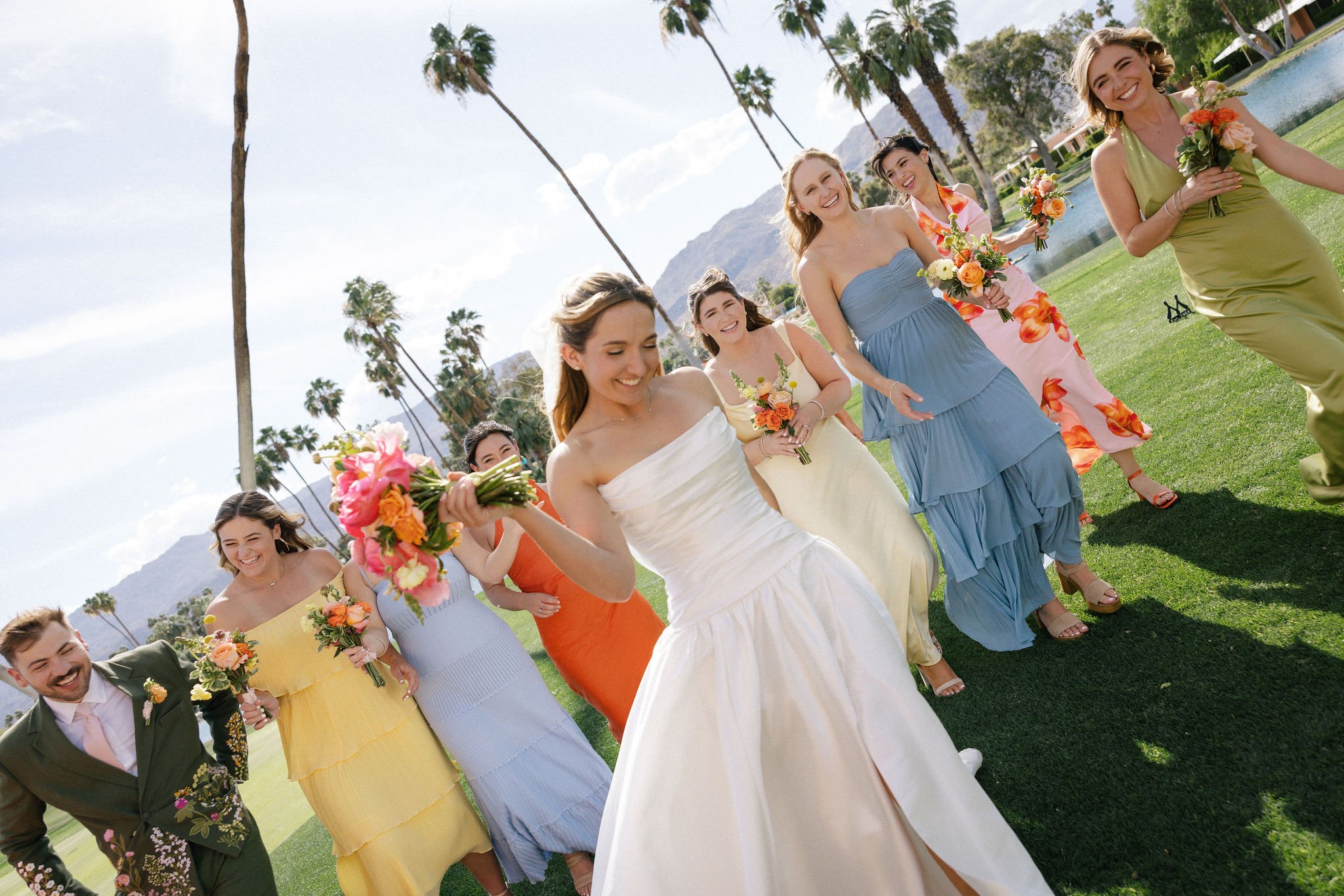 Bridesmaids walking having fun wearing bright citrus colors in Palm Springs