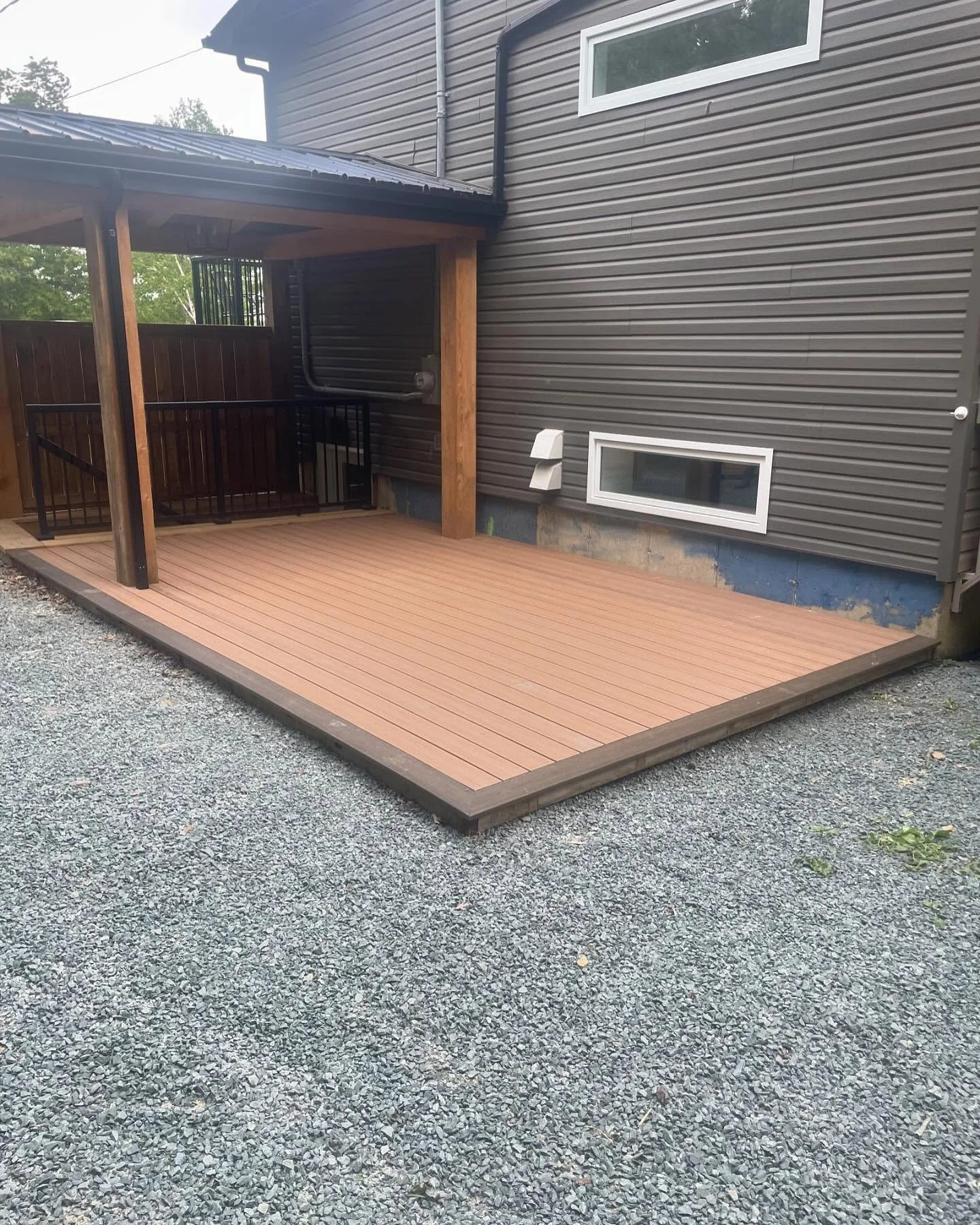 Ground level composite deck we finished today under a timber frame roof we built last year.
