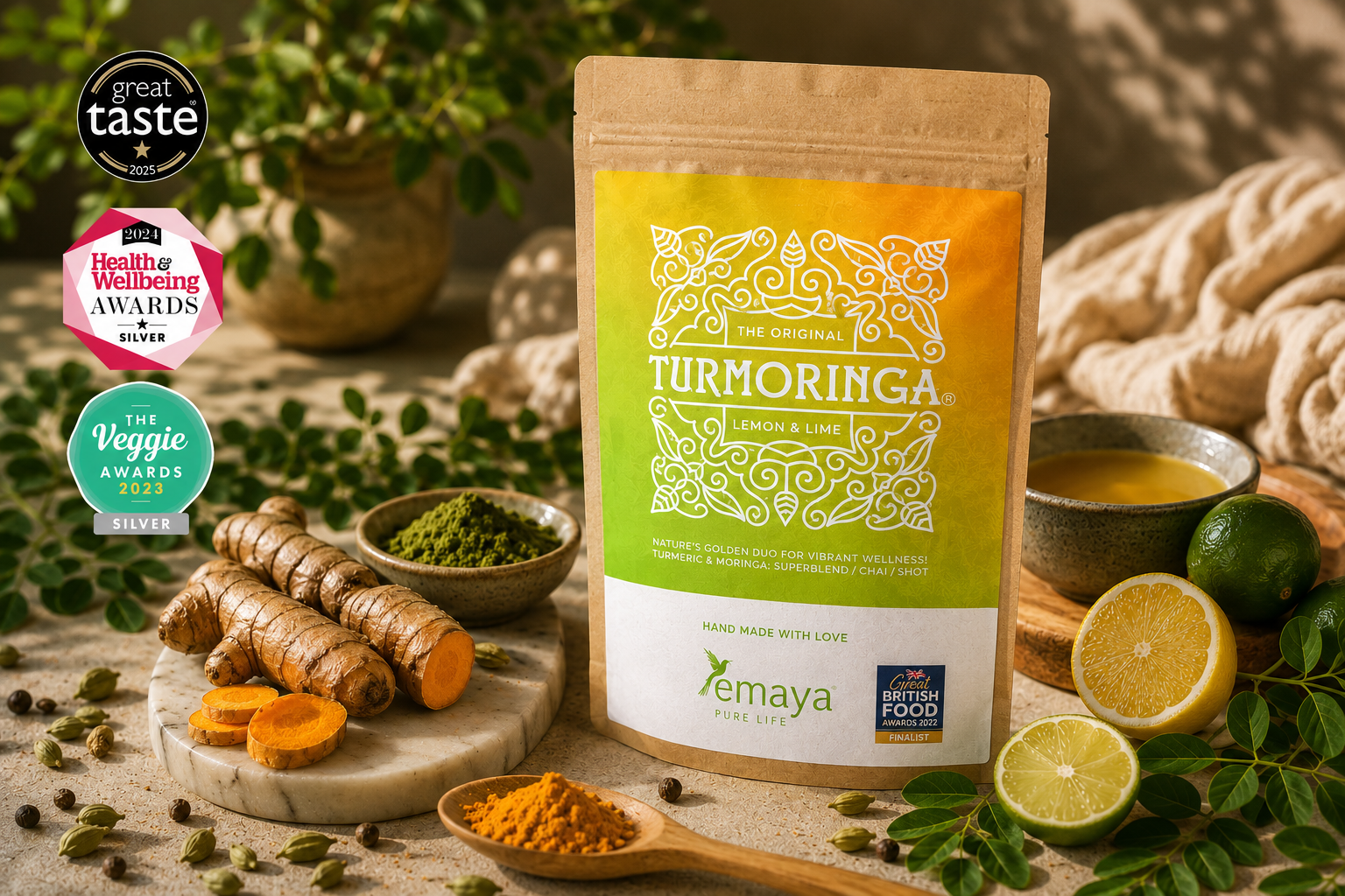 Package of turmeric and lime flavor turmeric, surrounded by fresh turmeric root, lime, turmeric powder, green moringa powder, and a cup of tea, with awards logos in the background.