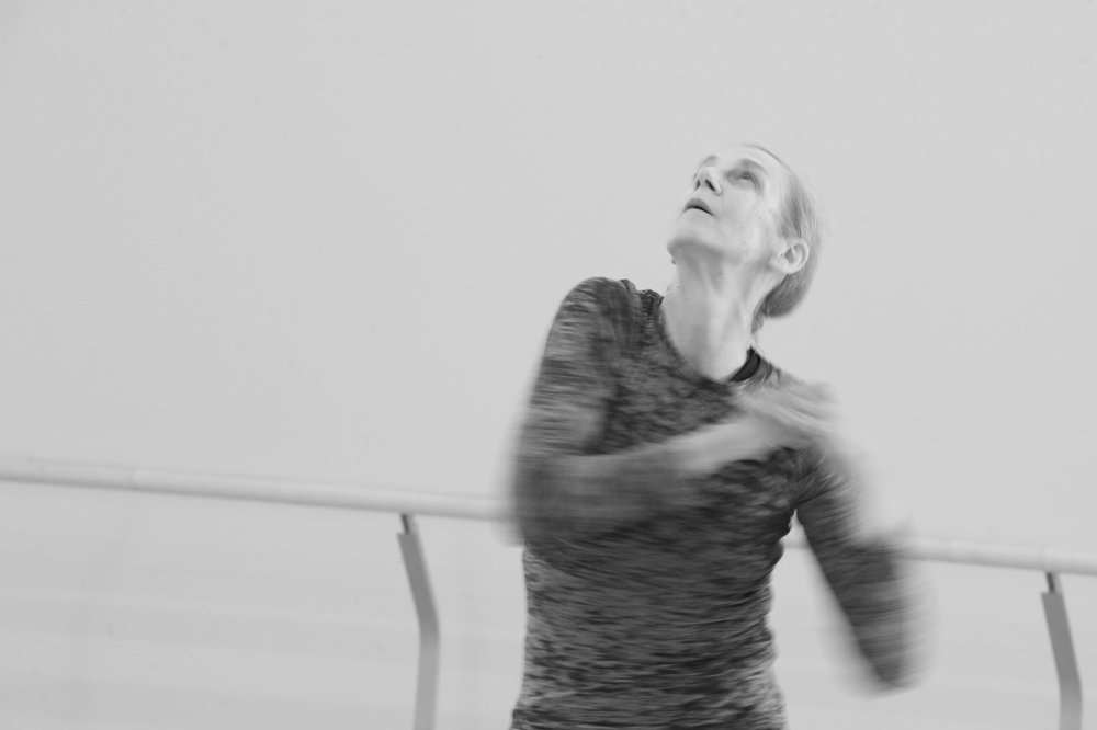  A close-up of Peggy Baker mid-movement. Her arms are blurry and her head is thrown back.  