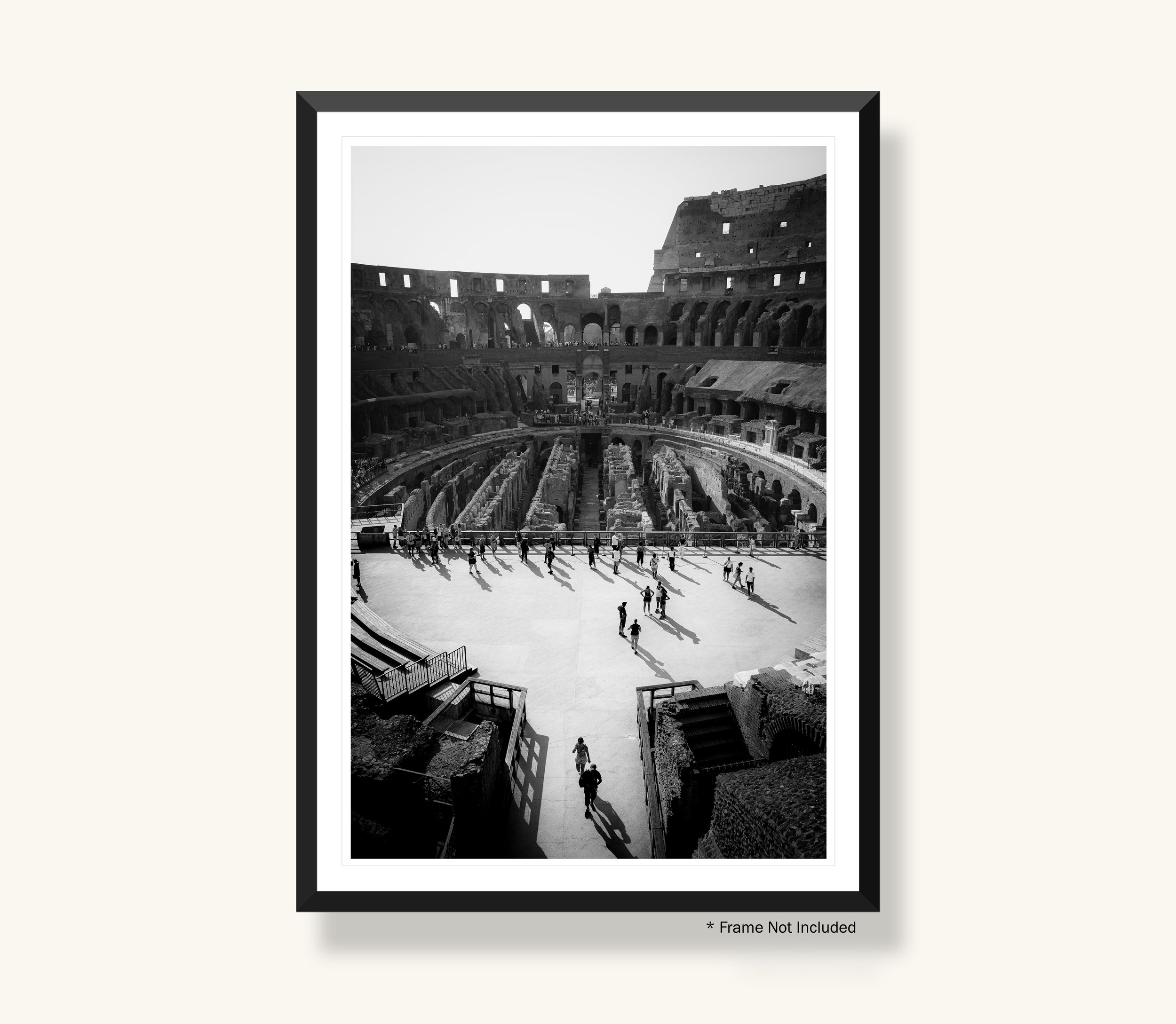 A framed black and white photograph of the interior of the Colosseum in Rome, showcasing its arches, tiers, and seated visitors, with a bright sky visible through the upper openings.