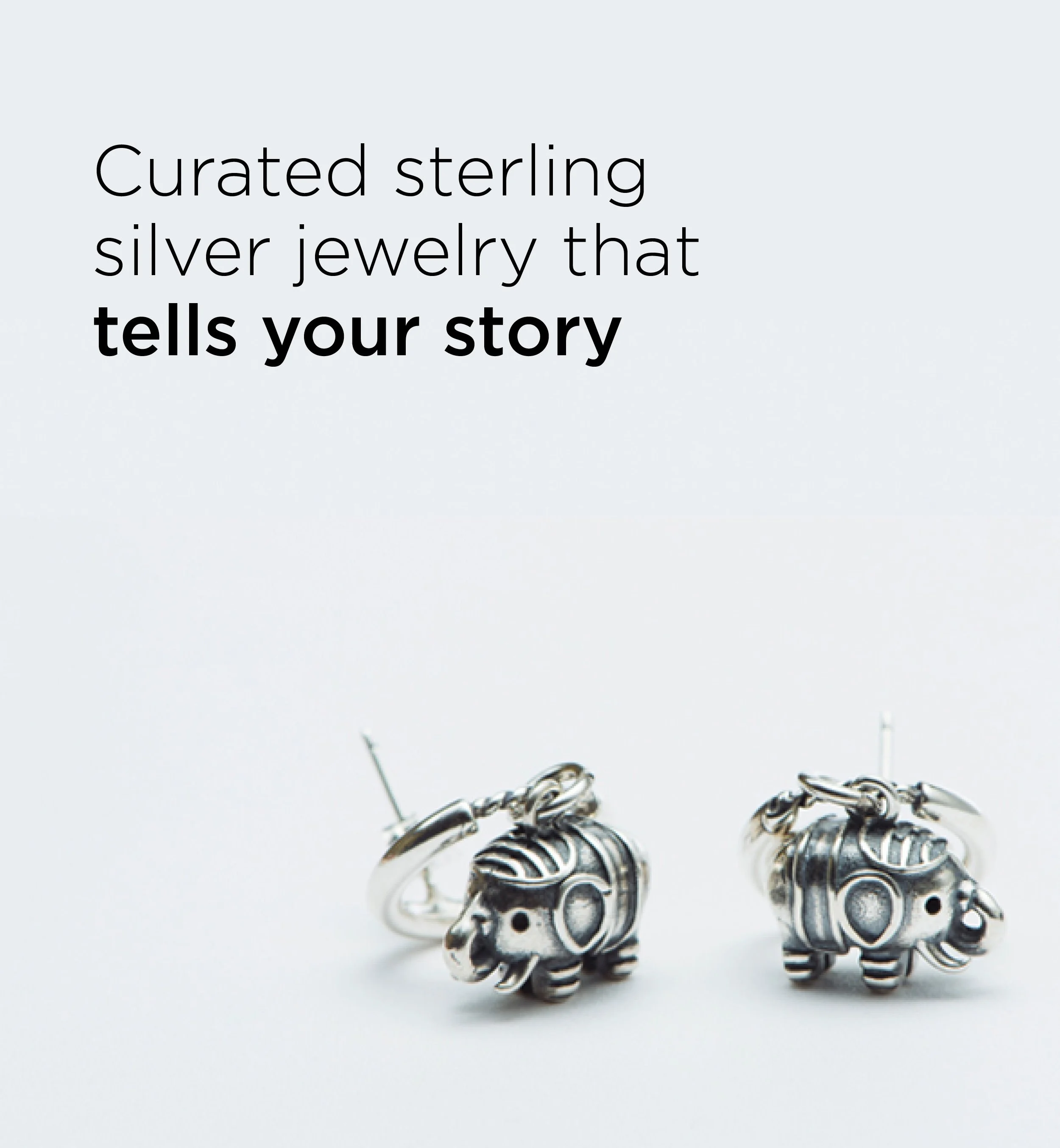 Sterling silver earrings shaped like elephants with engraved details, positioned on a white background.