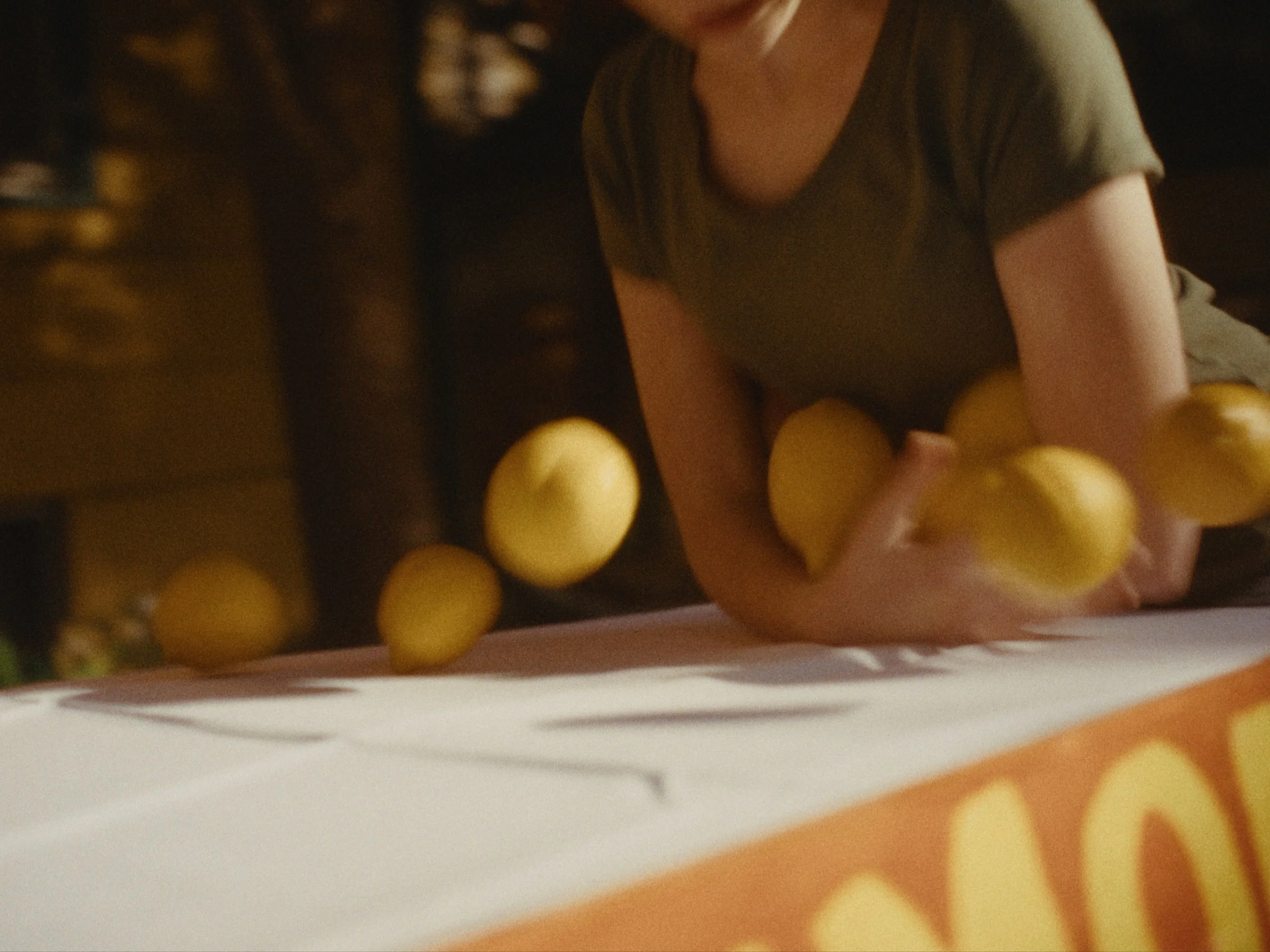 Close-up of a person wearing a dark shirt with a group of yellow balls for a game, possibly a child playing a game with yellow balls.