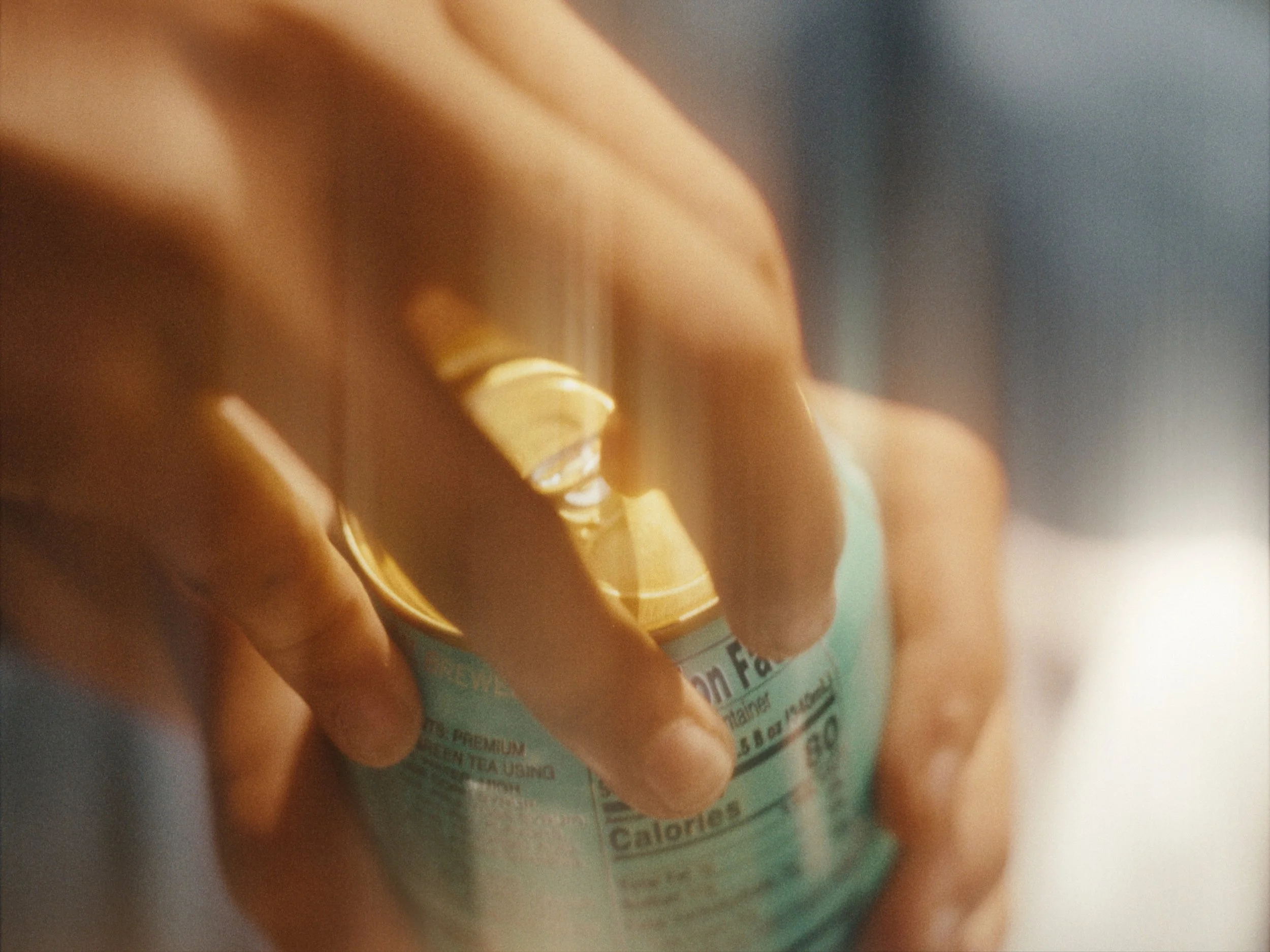 Close-up of a hand holding a bottle of supplement or medication with a label that is partially visible.
