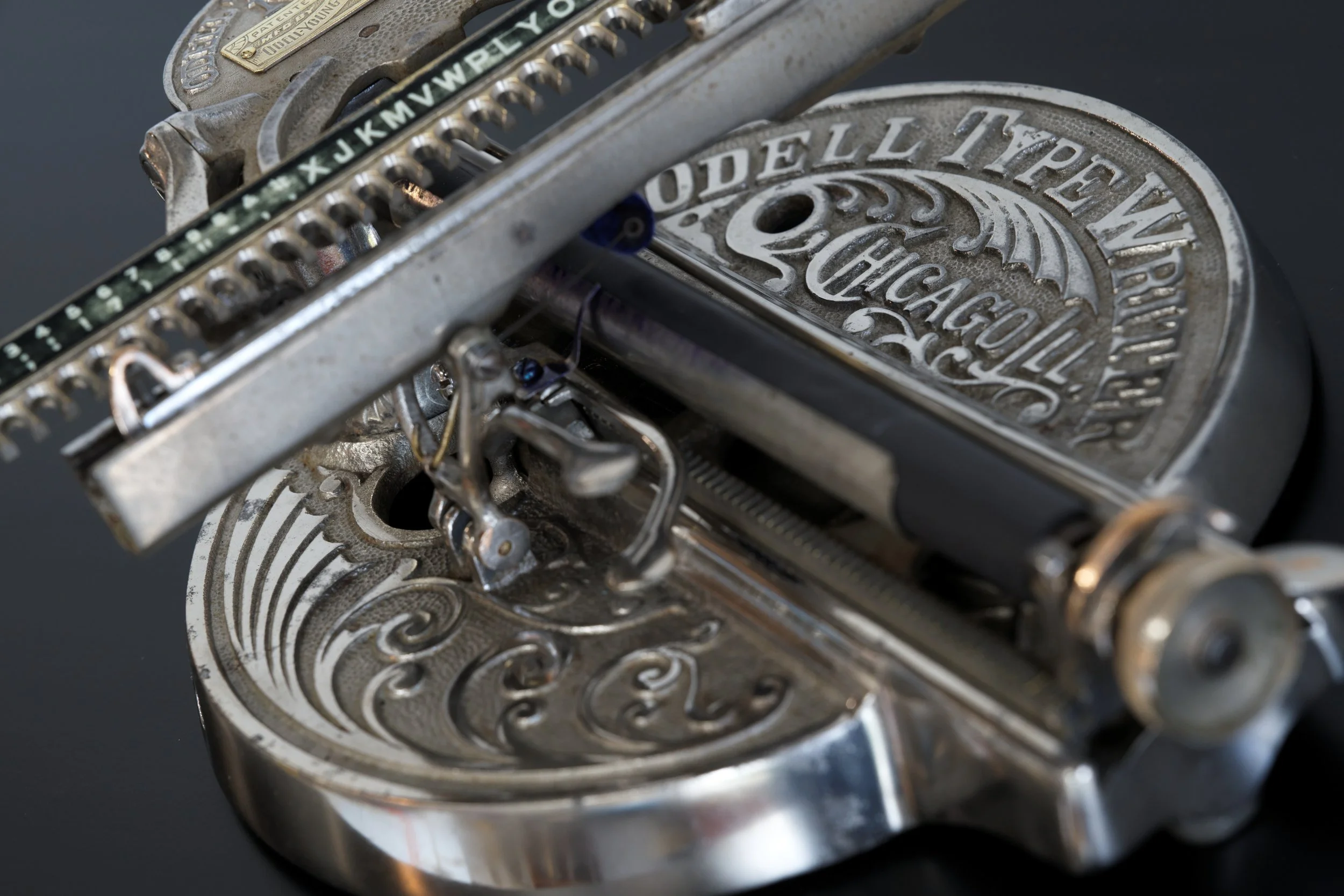 Closeup of the 1890 Odell Model 3 Typewriter showing the decorative base stating Made In Chicago