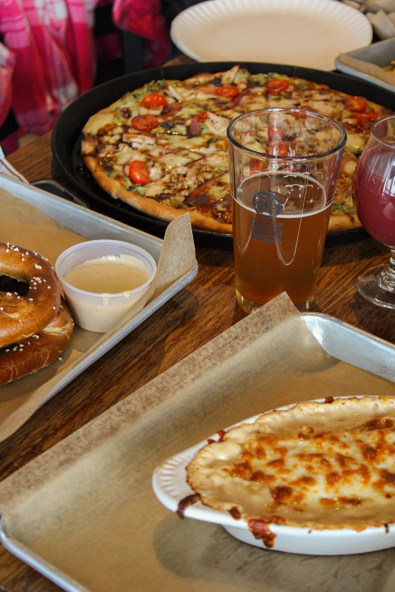 Beer with pretzel, and pizza around it