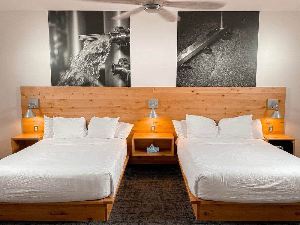 A modern room at The Lodge at Grist Iron with two beds and a wooden headboard