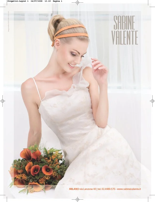 A young woman with light skin and blonde hair styled in a high ponytail with orange headbands, wearing a white dress, holding a bouquet of orange calla lilies and greenery, smiling and looking down. The background is light with sheer curtains. Text on the image says 'Sabine Valente' and contact information at the bottom.