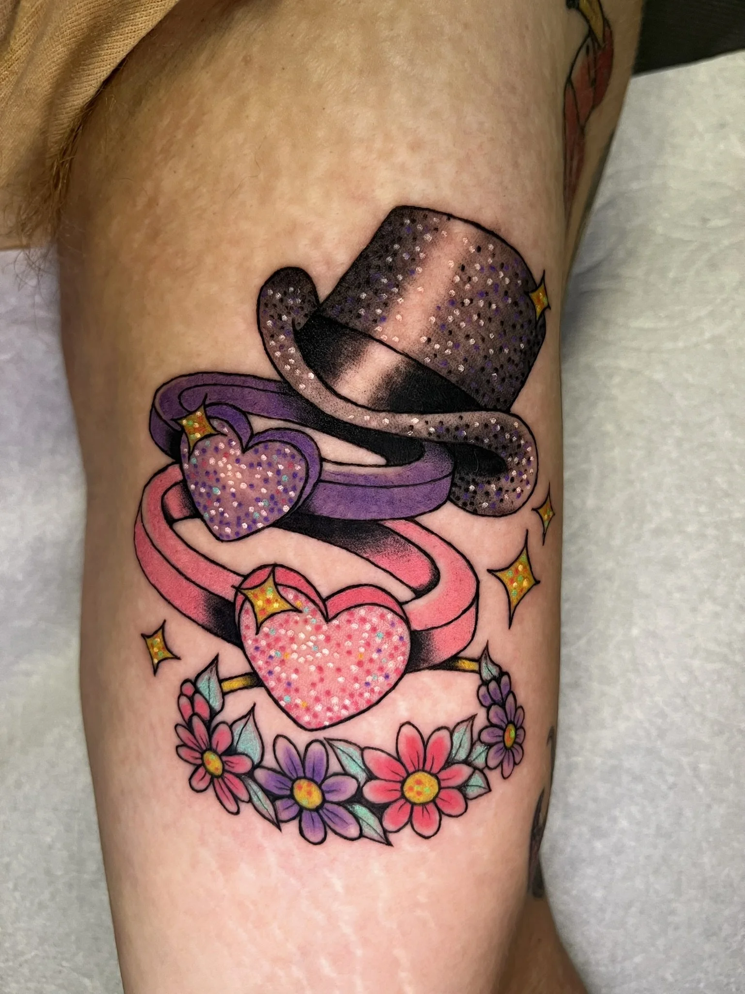 Two rings, a top hat, and a flower crown, all done in colorful, glittery style
