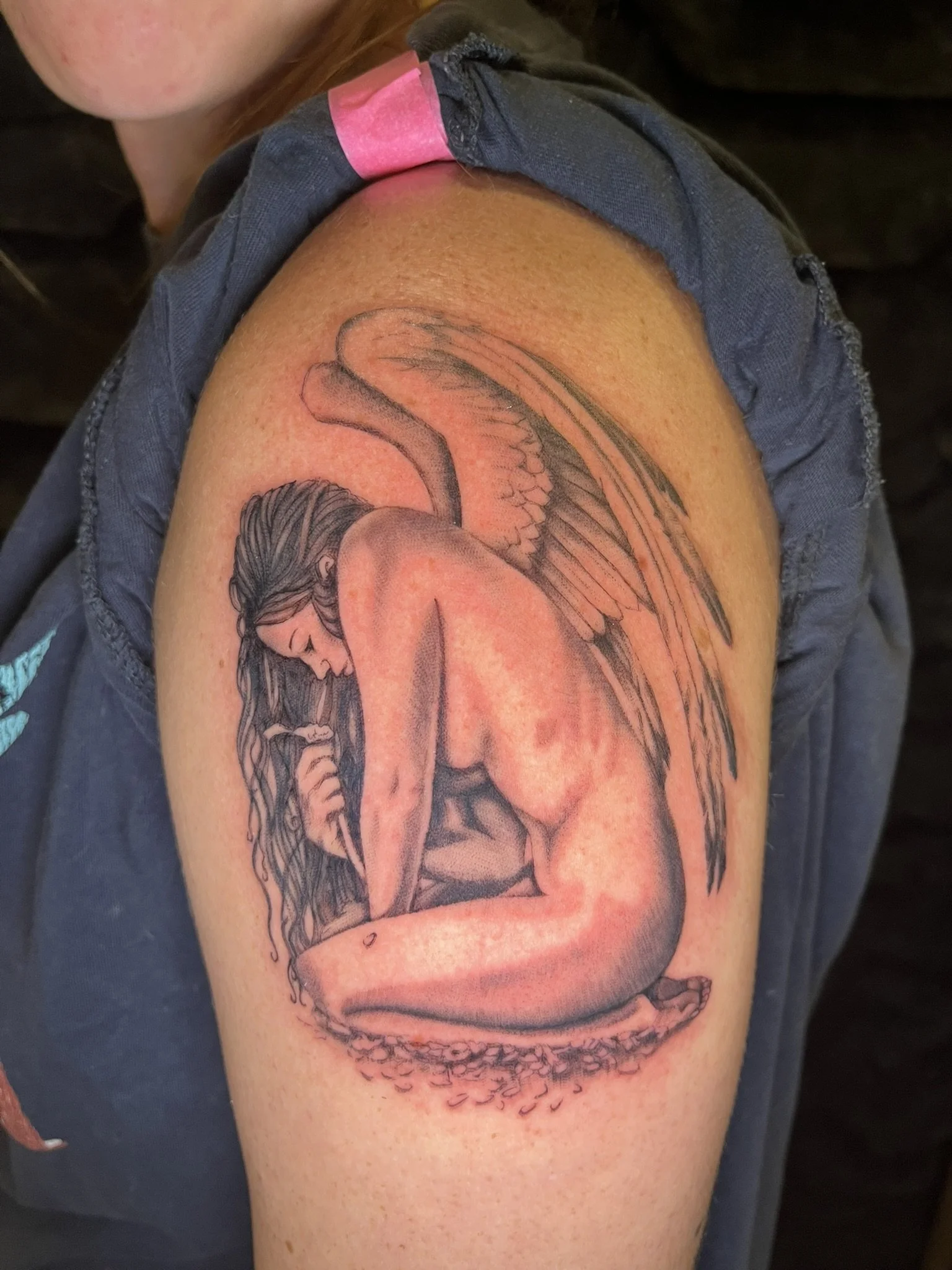 Black and grey "realistic" angel, on her knees curcled over looking forlorn, on arm arm