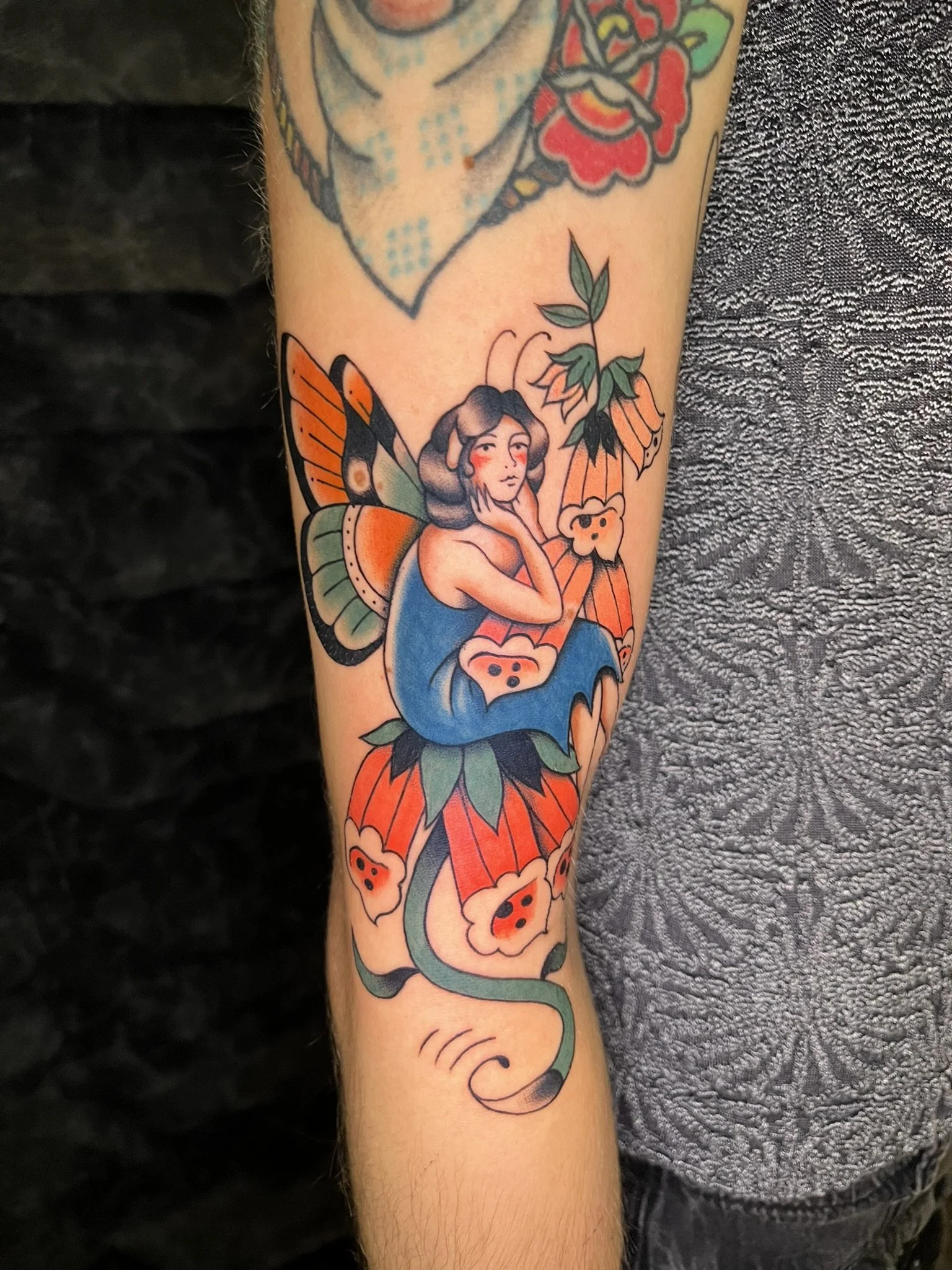A colorful traditional style folky fairy tattoo