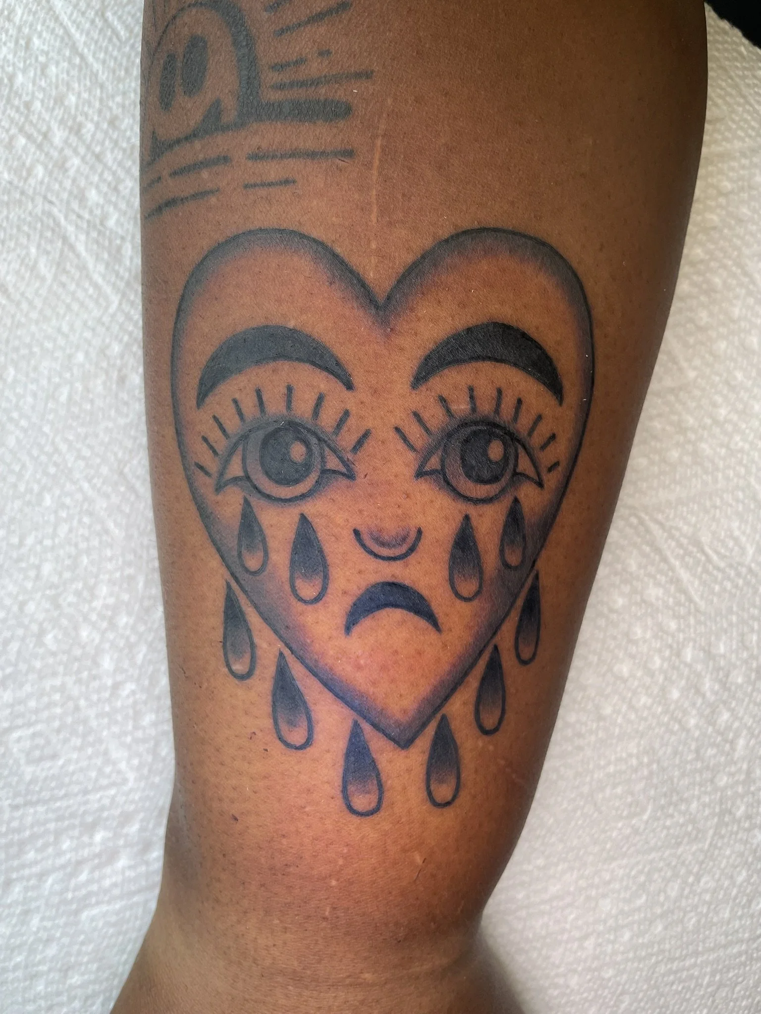 A crying heart, originally tattooed by Bert Grimm, in black and grey