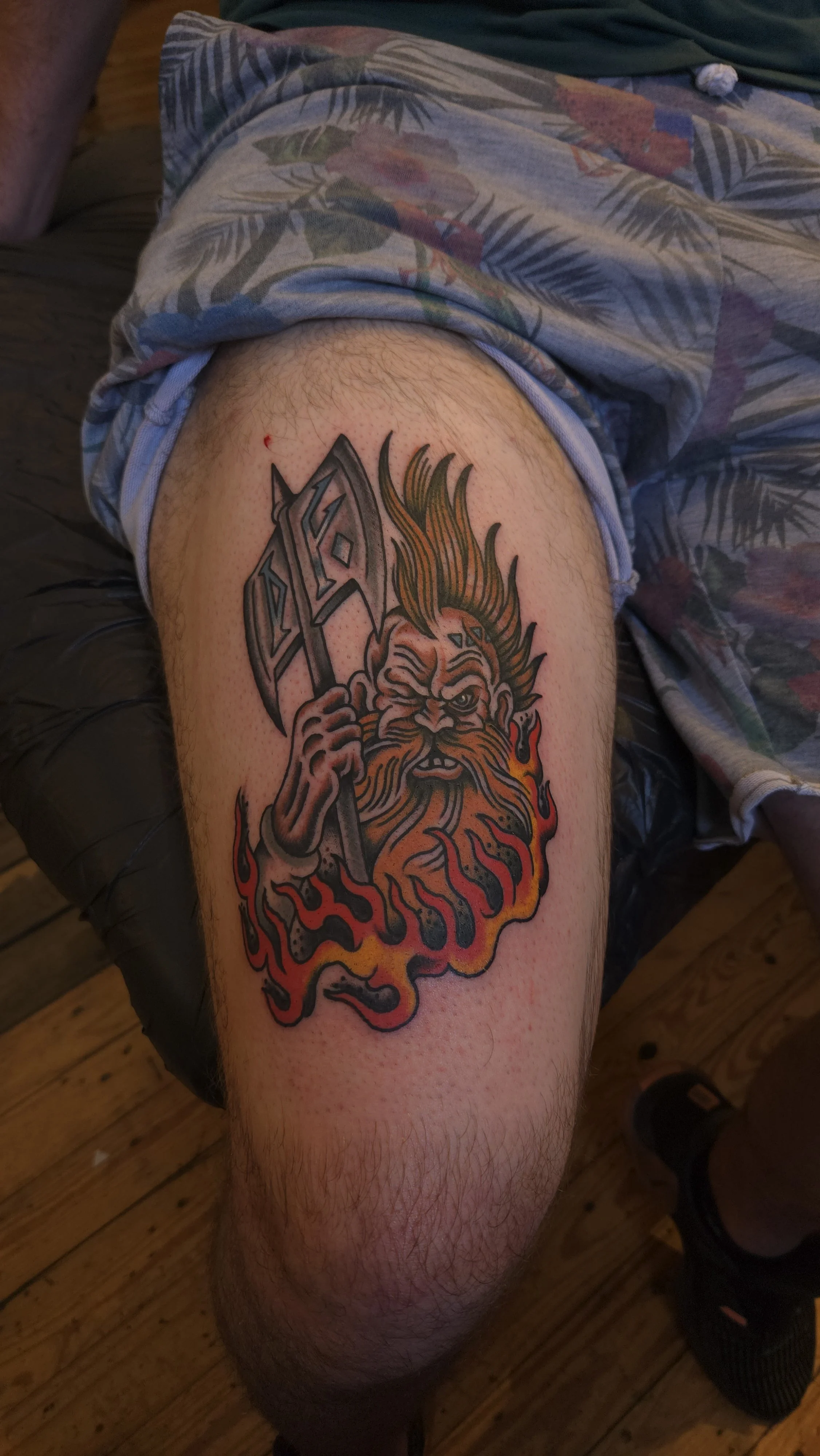 A fantasy Tolkien-style Dwarf with a large axe, surrounded by flames. It is referenced from a Warhammer dwarf, with a large, blonde mohawk and big, red beard.