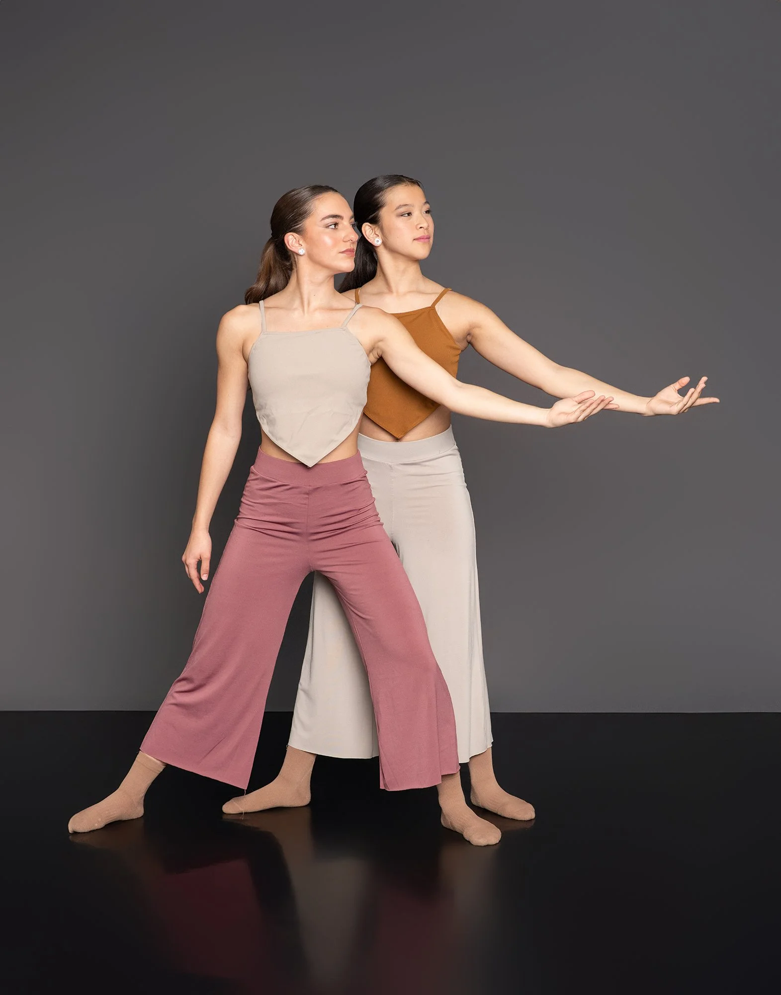 Two female teenage dancers in mauve, beige, ochre costumes