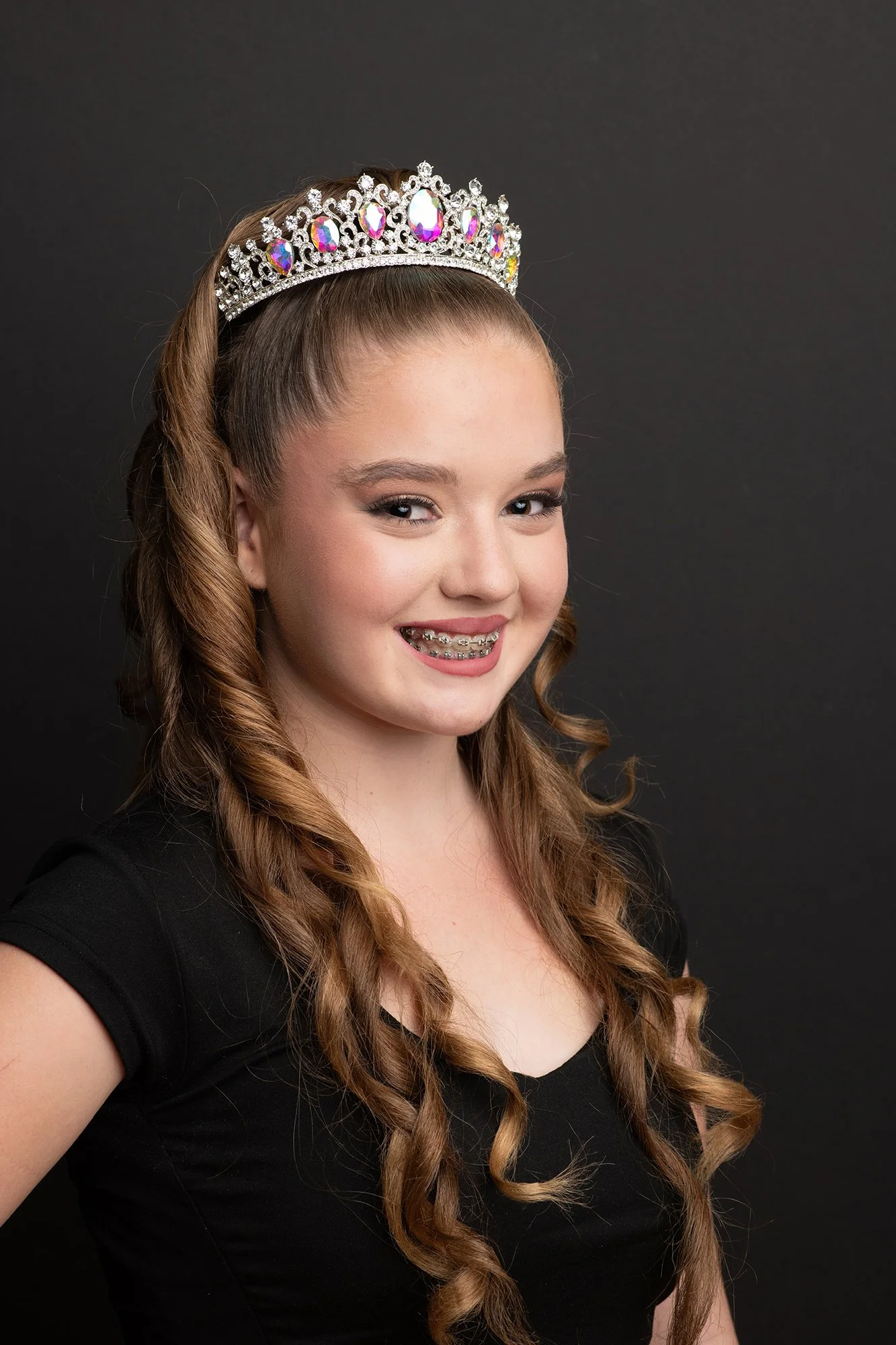 Blonde curly hair teenager wearing tiara headshot