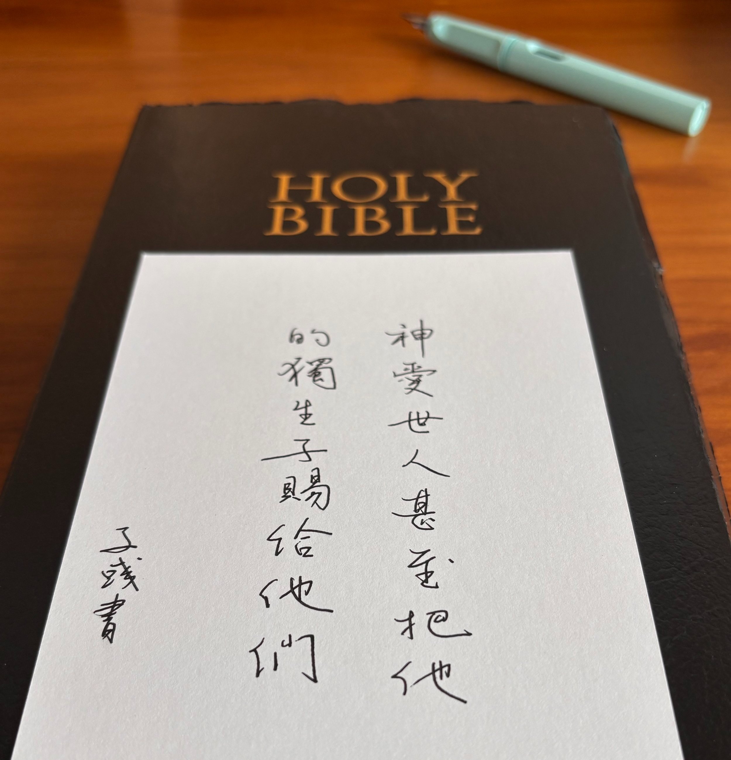 Bible and a card with a bible verse written in Chinese calligraphy