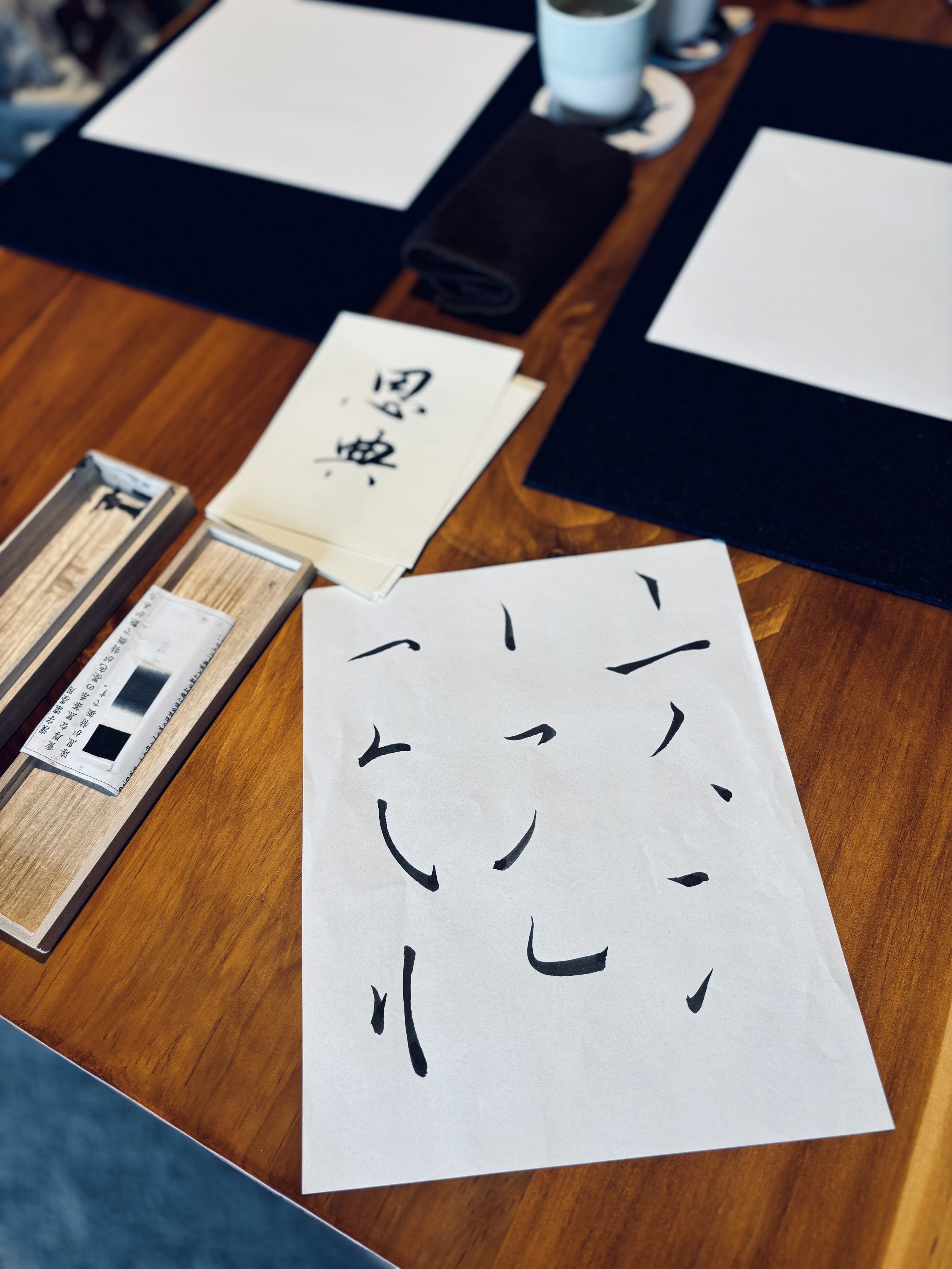 A piece of paper showing Chinese calligraphy strokes on the table