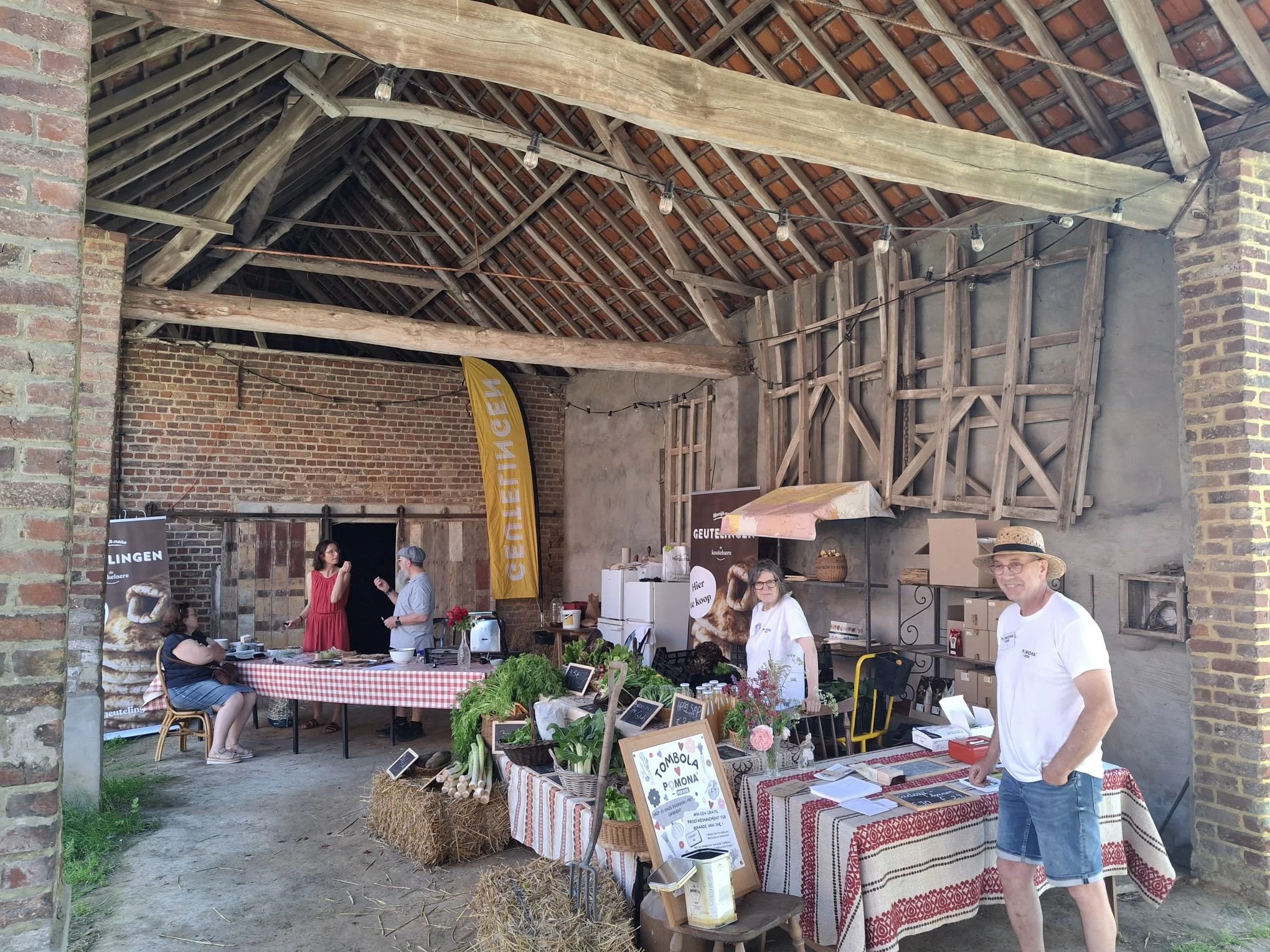 Binnenmarkt met marktstandjes en mensen in een historische boerderij