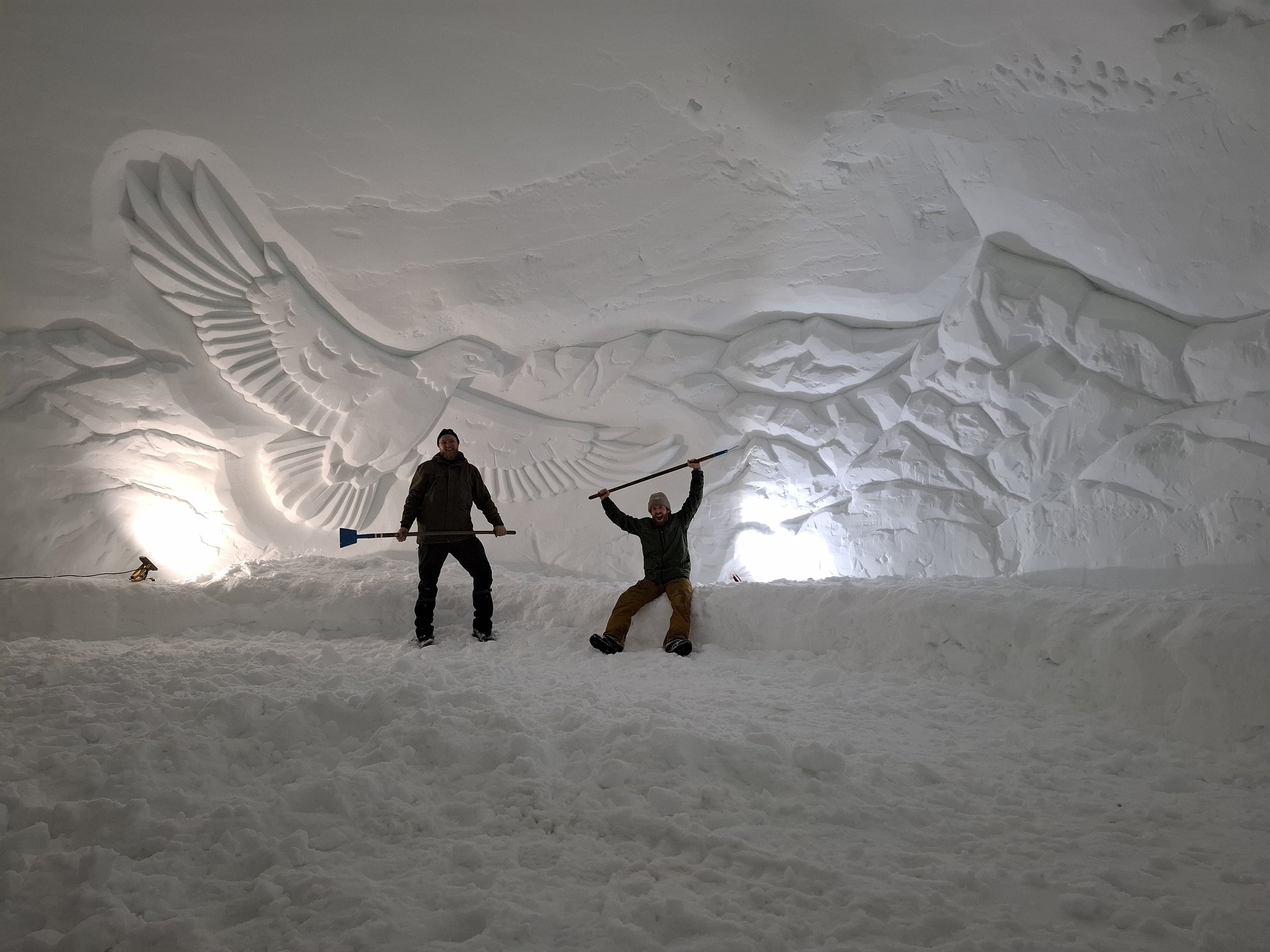 Schneeschnitzerei Adler und Bergkette und Künster im Vordergrund in Fondueiglu Engstligenalp