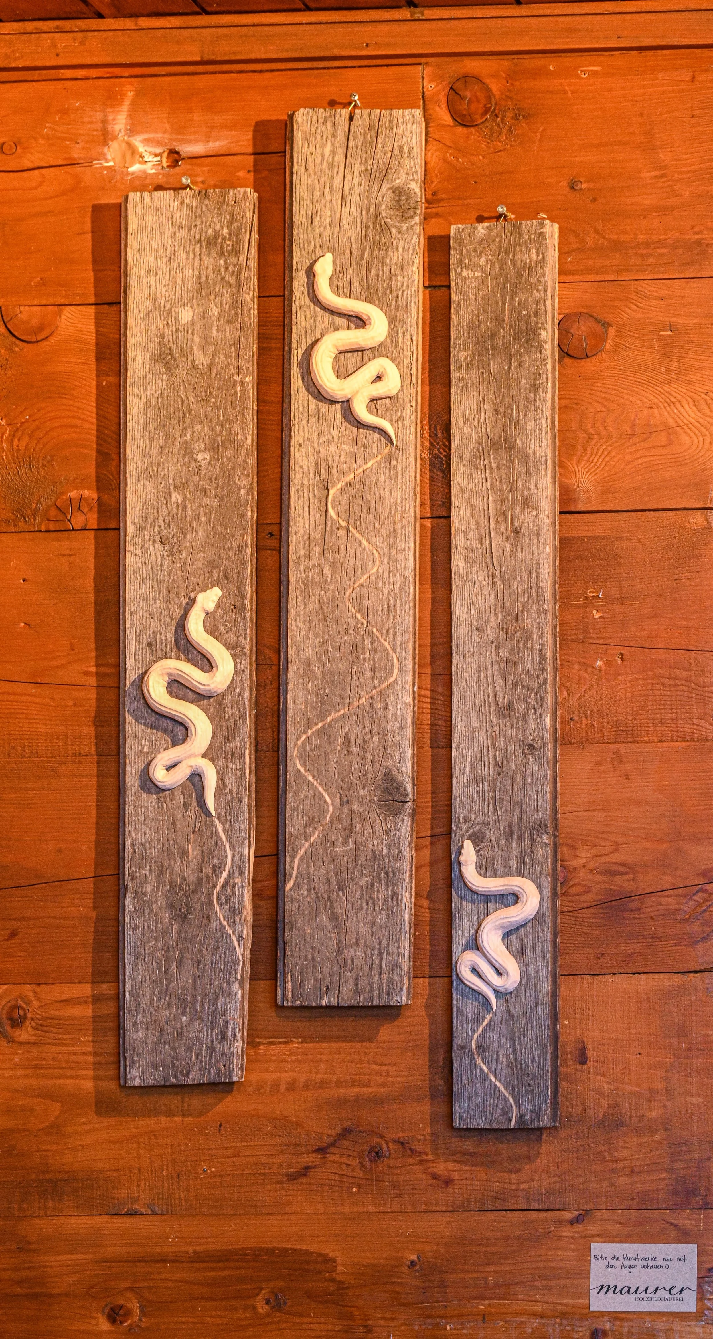 Schlangen geschnitzt aus Lindenholz, auf Altholzbretter montiert