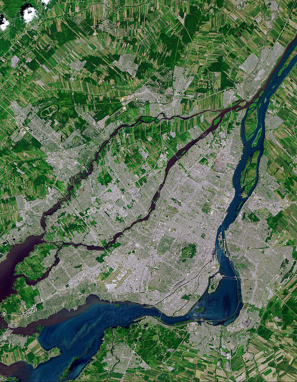 Satellite view of a city with various rivers running through it, surrounded by green farmland.