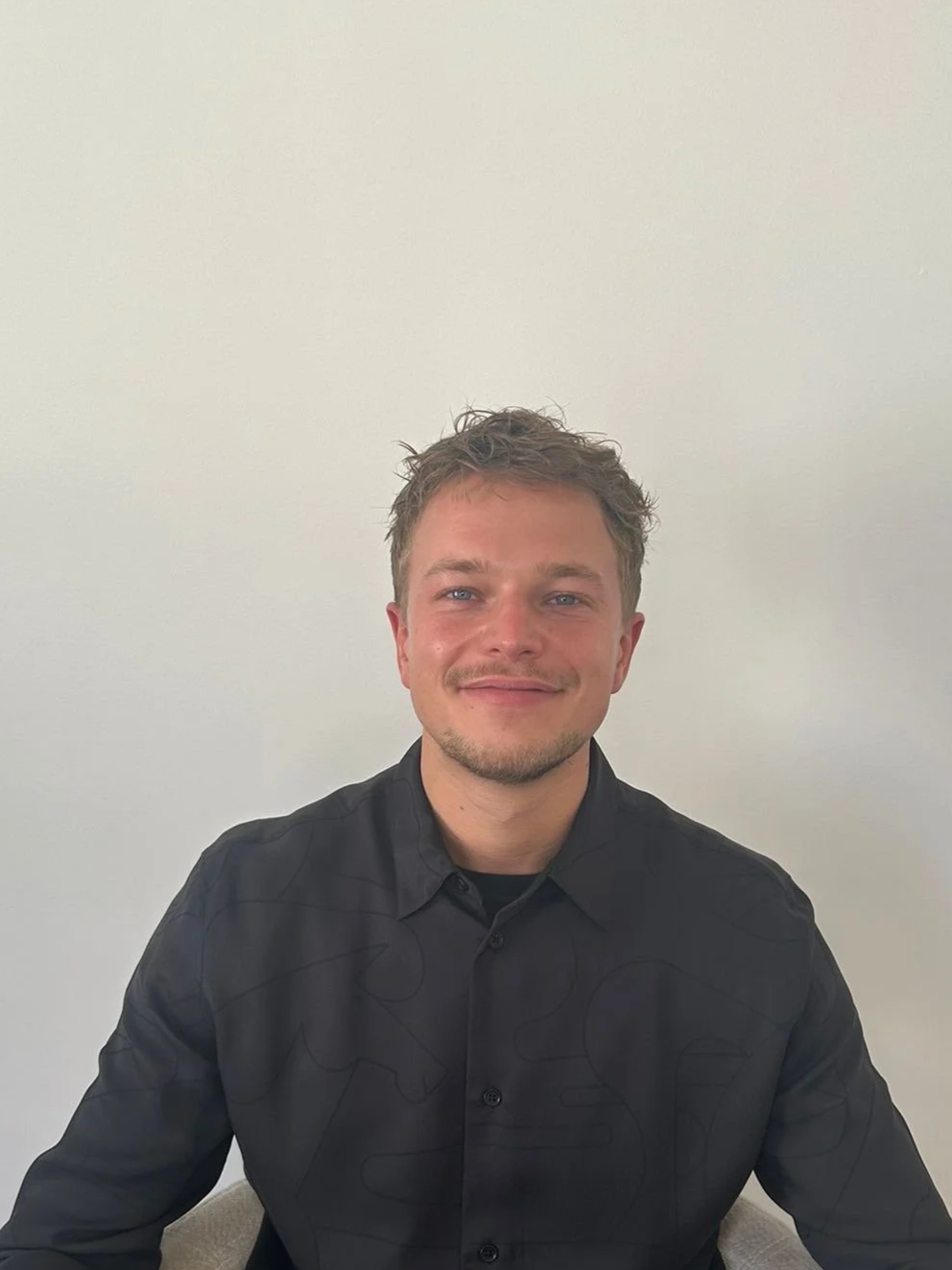 homme souriant habillé en chemise bleu foncé