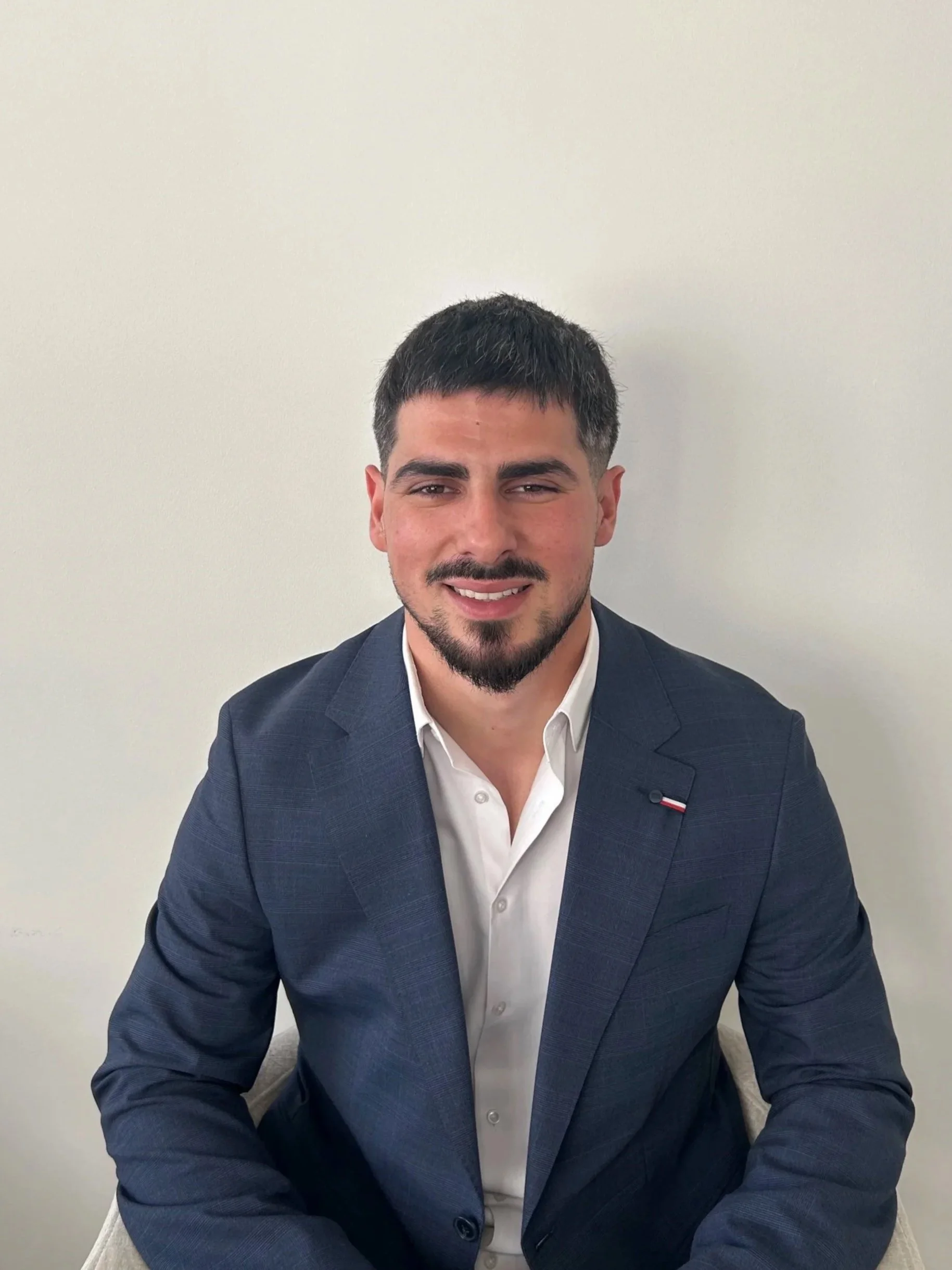 homme souriant habillé en costume bleu marine