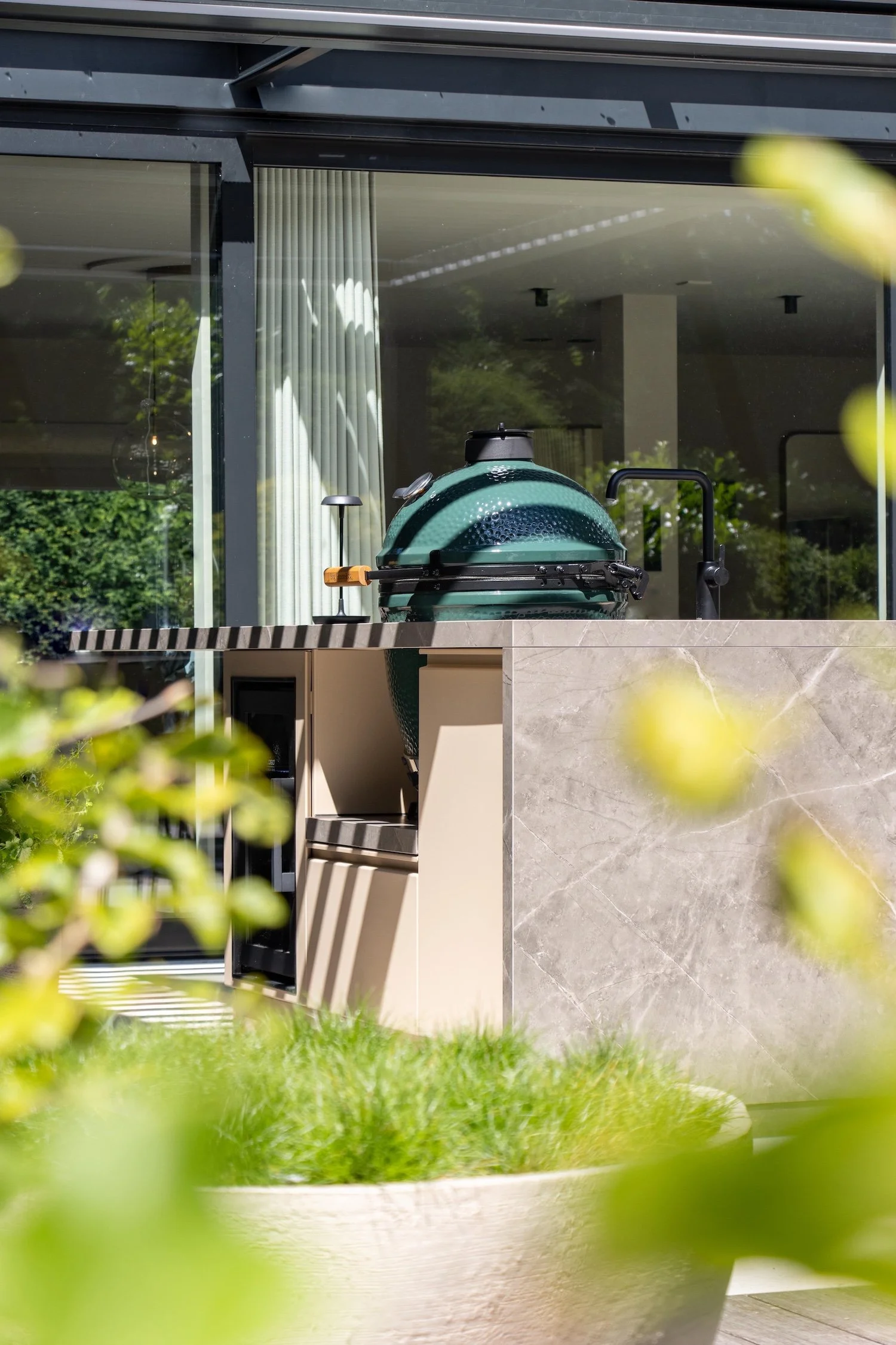 Gerealiseerde buitenkeuken met kamado geïntegreerd in een moderne tuinomgeving