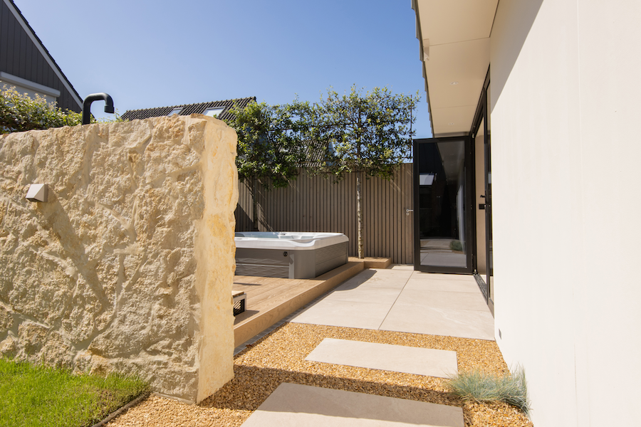 Wellnessplein met flagstone scheidingsmuur en spa en ijsbad