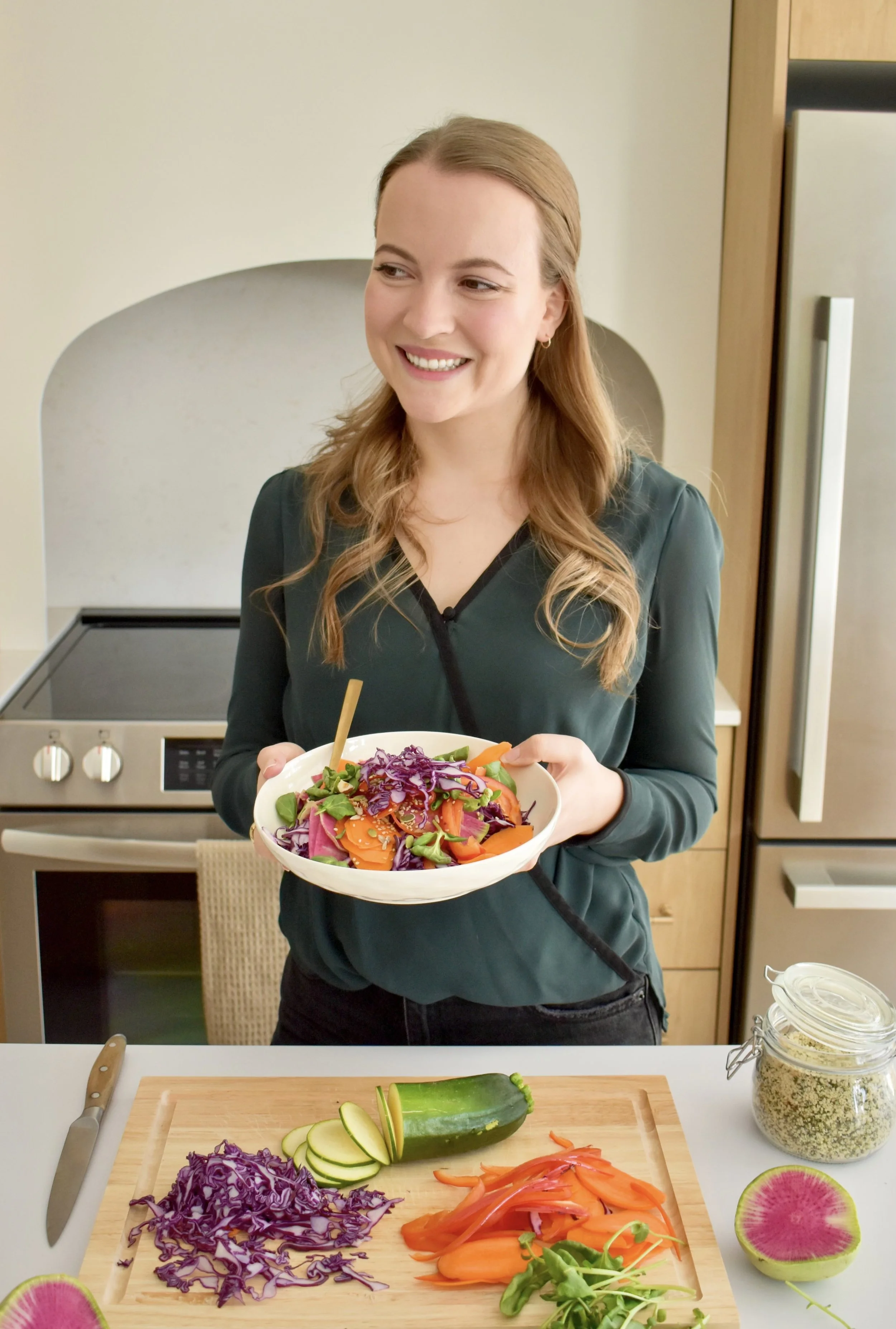 Clémence Cahill, nutritionniste-diététiste, debout dans sa cuisine avec un bol de salade colorée