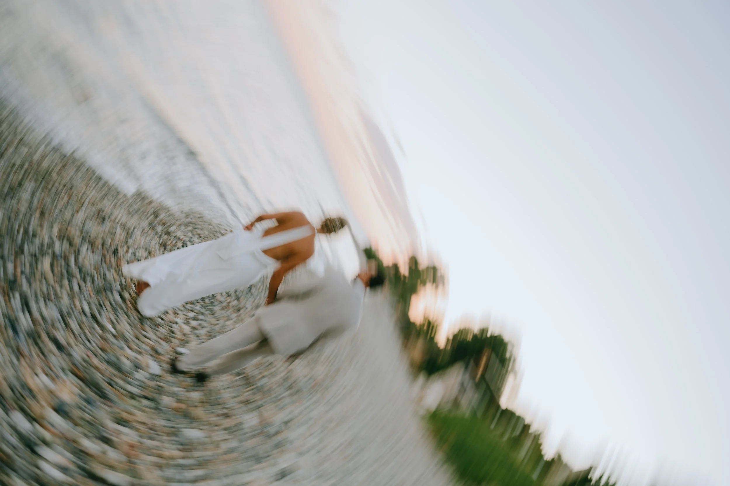 A couple walking on a beach during sunset, with blurred motion effect.