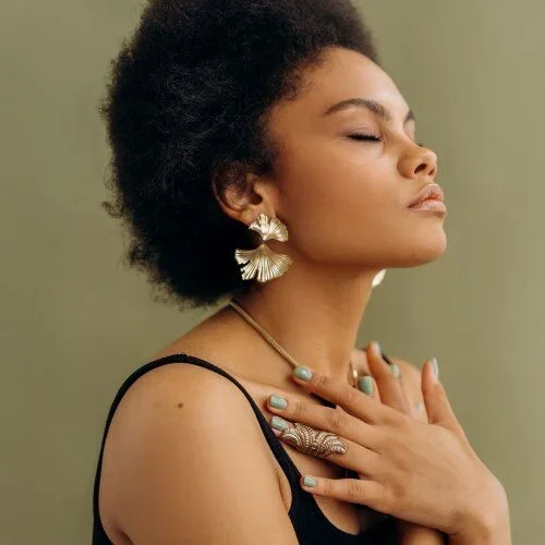 woman with closed eyes touching her chest with crossed hands
