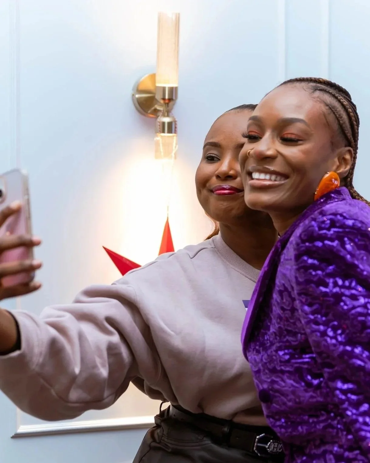 Two women taking a selfie together, smiling and posing for the camera.
