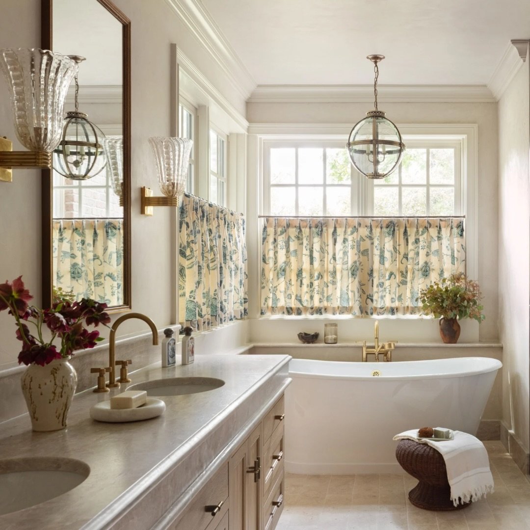 Layered lighting is one of the most important elements of creating a bathroom that feels as good as it functions.

In this Chicago primary bath, we used two different sconce styles, a pendant, recessed lighting, soft caf&eacute; curtains to preserve 