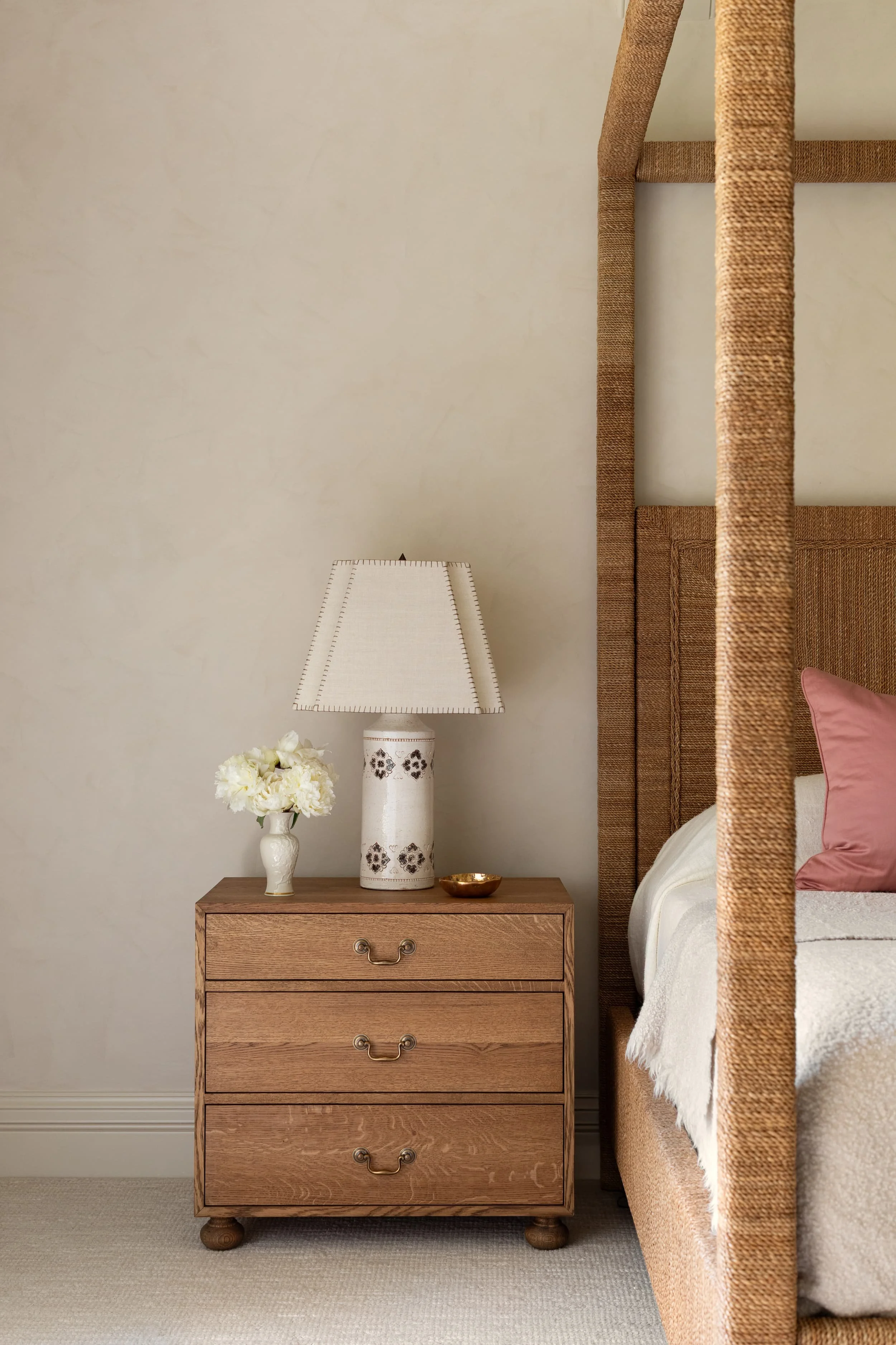 Custom oak nightstand with ceramic lamp and fresh florals adds timeless character to the Chicago primary suite renovation.